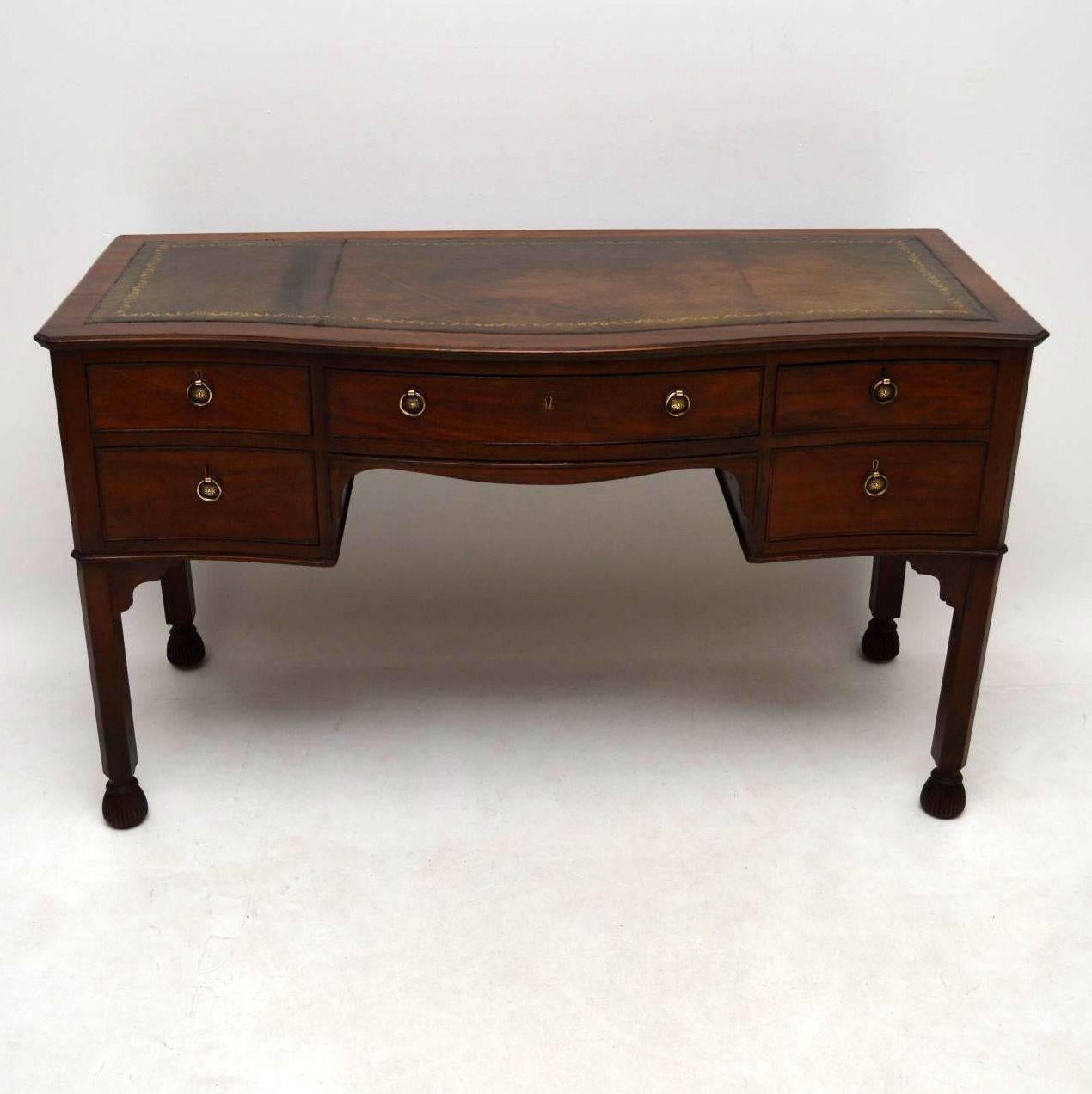 Antique Victorian mahogany desk of an unusual design and of very good quality, dating to around the 1890s period. It’s in excellent condition and the leather is hand colored. There are five drawers, the middle one being bow fronted. They all have