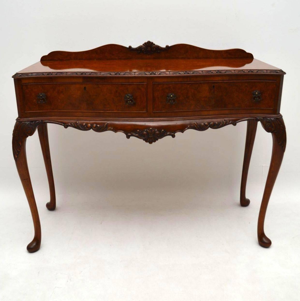 Fine quality antique burr walnut side table server dating from the 1930-1950s period and in good original condition. It has a shaped back gallery, with carving in the middle. The top is a tight burr walnut and it’s carved all around the top. The