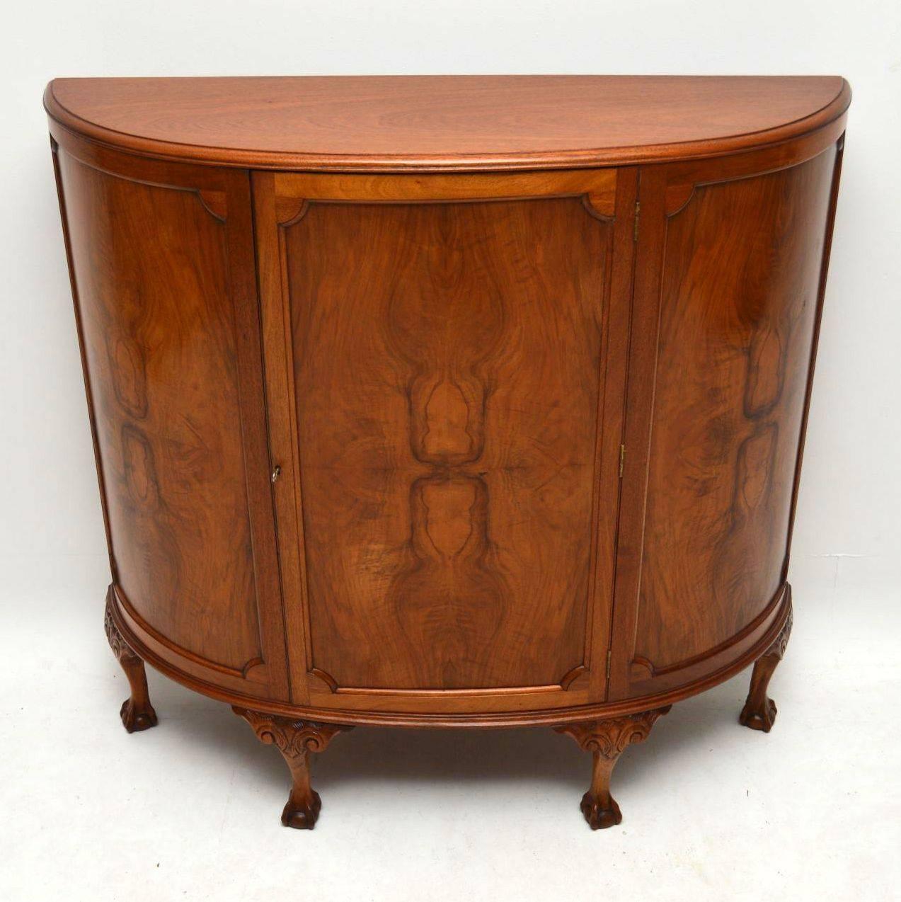 This antique bow fronted walnut cabinet is a very practicable piece of furniture, because it doesn't come out very far from the wall & has a lot of storage inside. It has three figured or burr walnut panels on the front & the centre one is a door