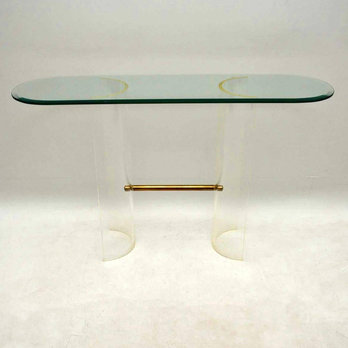 A very stylish and unusual console table, this dates from the 1970s. It was most likely made in France or Italy, and it's of excellent quality. The base is curved perspex, joined at the base by a brass rod. The top is clear bevelled glass. The