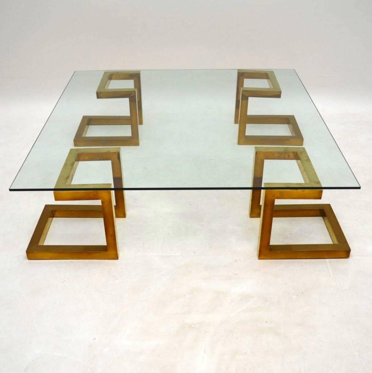 A stunning and very impressive vintage coffee table, this was made in Italy, it dates from the 1970s. It has four separate supporting brass columns and a thick, clear glass top. The condition is superb for its age, with some minor wear commensurate