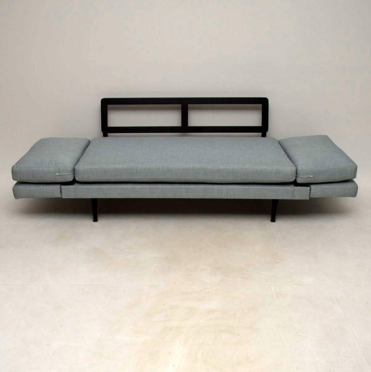 A compact and beautiful vintage sofa bed dating from the 1950s, this is a very practical and very comfortable piece of furniture. The arms drop down and the back cushions can be placed at either end to extend this into a bed. The back support also