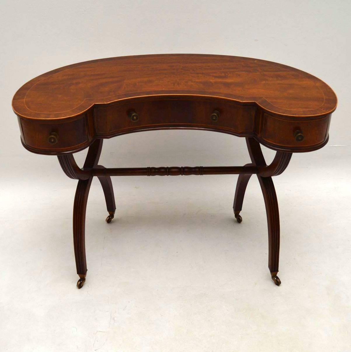 This mahogany kidney shaped table could be used as a desk or dressing table. It’s antique, dating from around the 1910 period and is in excellent condition. This piece is also very fine quality. The top has an inlaid crossbanded edge. There are