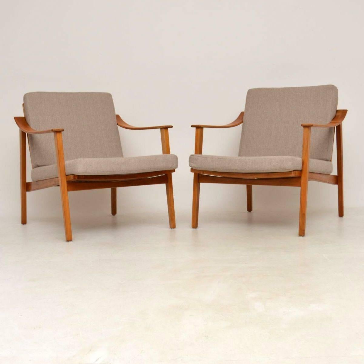 A very stylish pair of vintage armchairs, these were made in Denmark and date from the 1950s-1960s. The frames are solid wood that looks like satin or cherrywood. The frames are clean, study and sound, with only some extremely minor wear. The