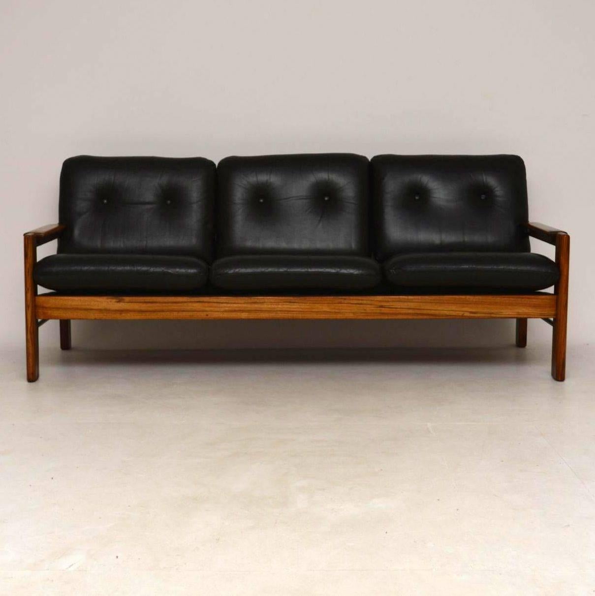 A top quality and very comfortable vintage sofa, beautifully made and in excellent vintage condition. At first we thought the frame was rosewood, but on closer inspection we think it’s heavily grained solid American walnut. The back and sides have