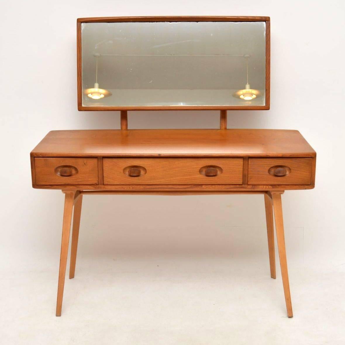 A stunning vintage dressing table by Ercol, this is made from solid elm and is in great original vintage condition, with only some extremely minor wear here and there. This has an adjustable mirror that can be tilted to varying angles or removed if