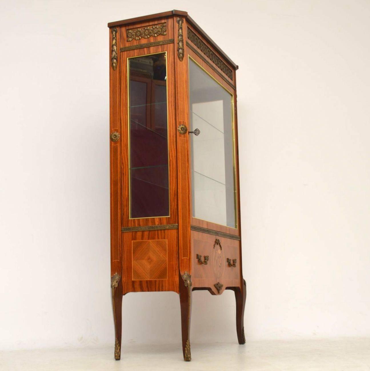 Antique Swedish Kingwood display cabinet of exceptional quality and in the manner of Louis XVI, neoclassical in style. This cabinet is predominately kingwood and rosewood, with inlaid panels and some intricate marquetry. It has gilt bronze mounts,