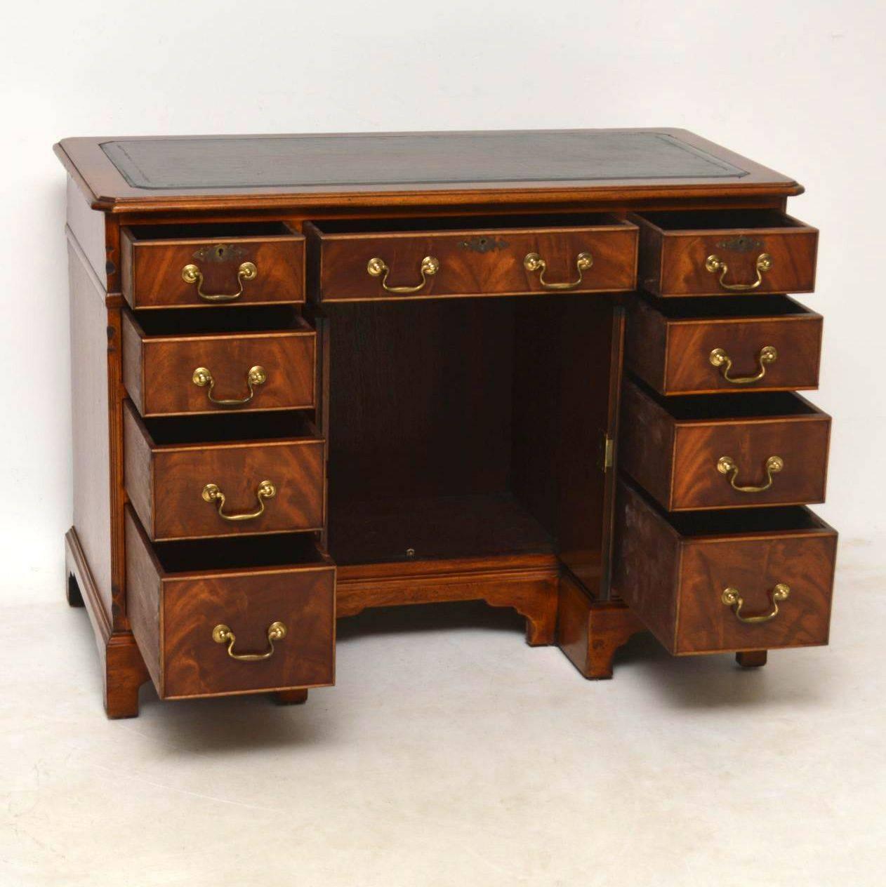 This antique mahogany desk is extremely high quality with some wonderful features and is in excellent condition. Most of these kneehole desks with the middle cupboard are always too narrow for kneehole space. This example has a double width kneehole