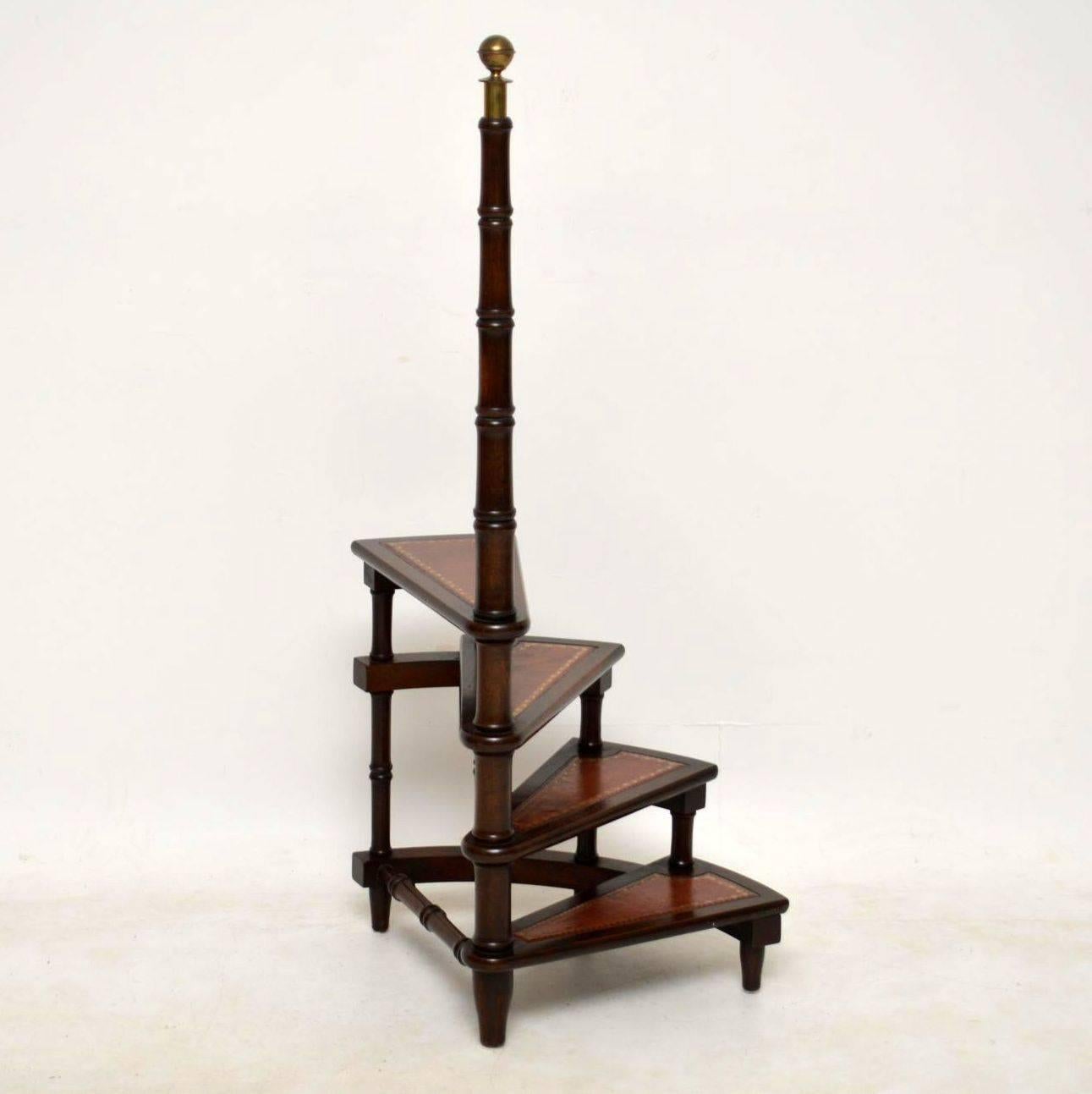 These antique spiral shaped mahogany library steps are becoming increasingly harder to find. This one is nice quality, in good original condition and I would date it to circa 1950s period. It has a bold turned upright topped with a brass finial. The