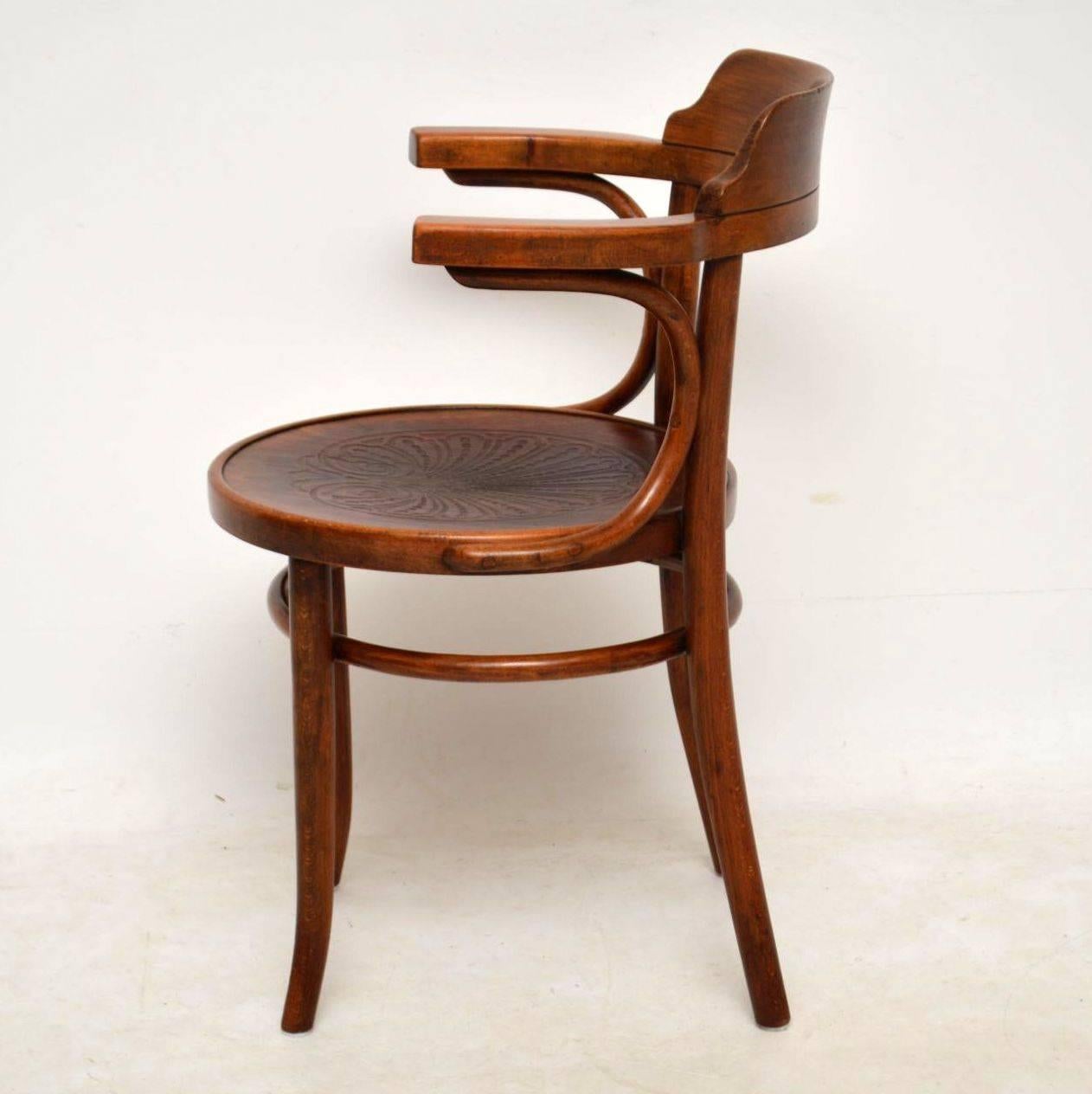 Pair of antique Thonet bentwood armchairs in good original condition. They are a good color with a bit of natural fade here and there. These chairs are structurally sound and they have the original embossed seats. We do have four of these chairs,