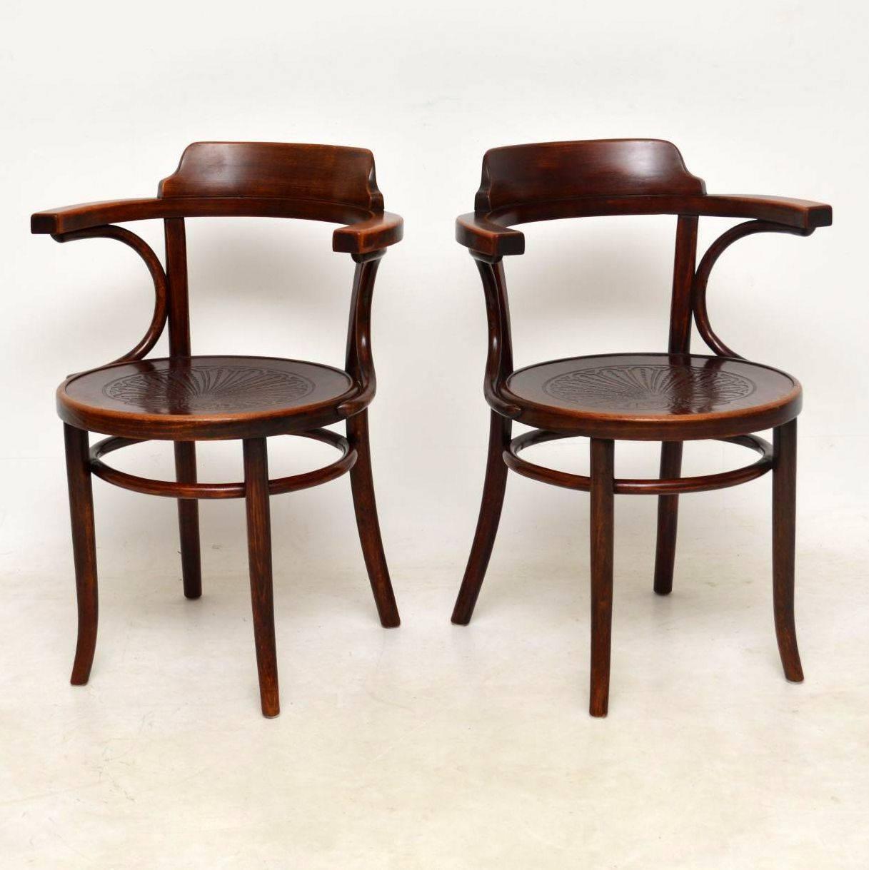 This pair of antique Thonet bentwood armchairs have an identical matching pair on another listing on the site. We got all four together. They are in good condition with a bit of natural fade in places. These chairs are very comfortable because of