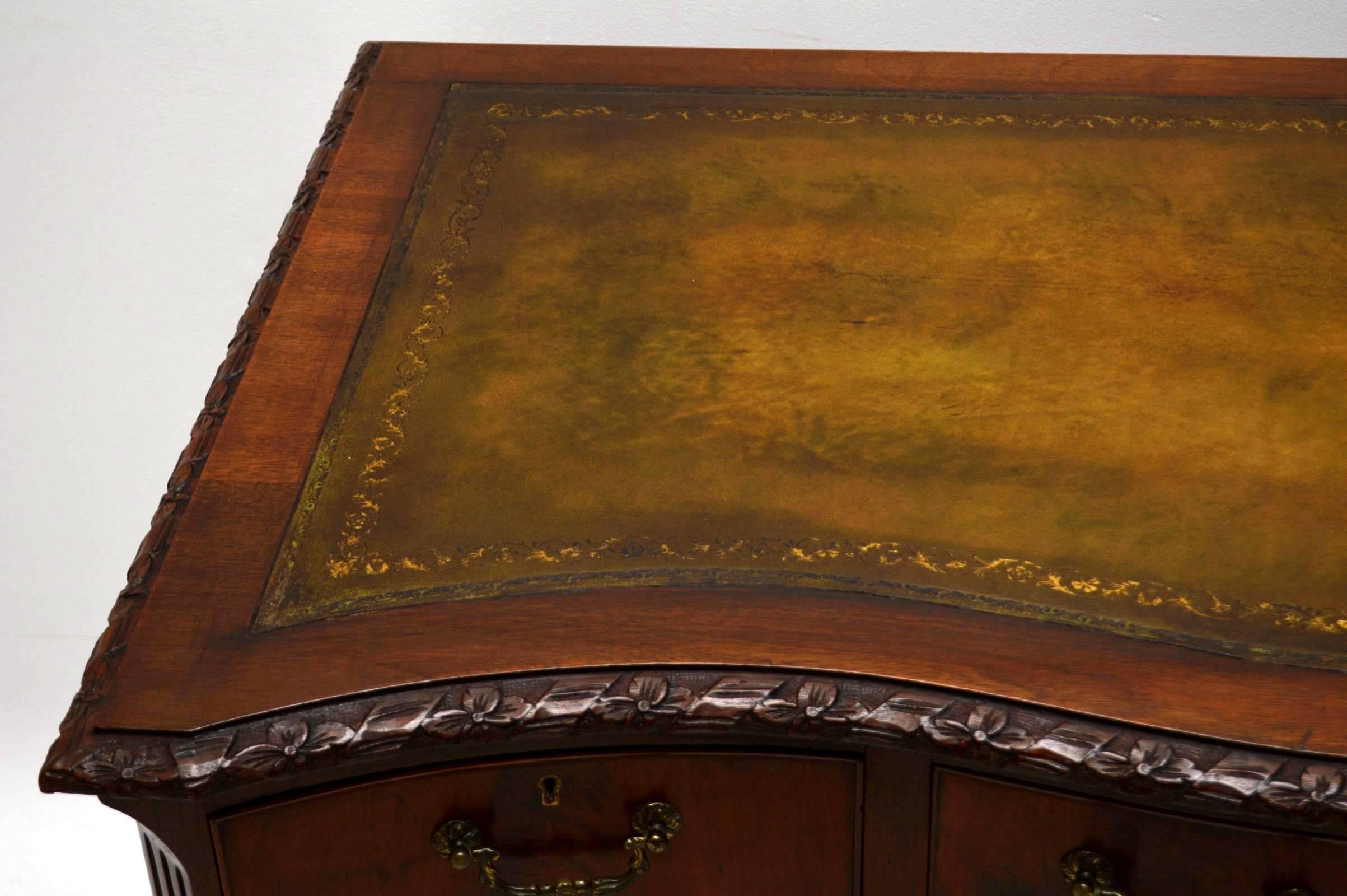 This antique mahogany desk is wonderful quality and very solidly built. It's very much in the Chippendale manner, dating from around the 1890-1910 period & is in excellent condition. The writing surface is a hand coloured tooled leather & it is