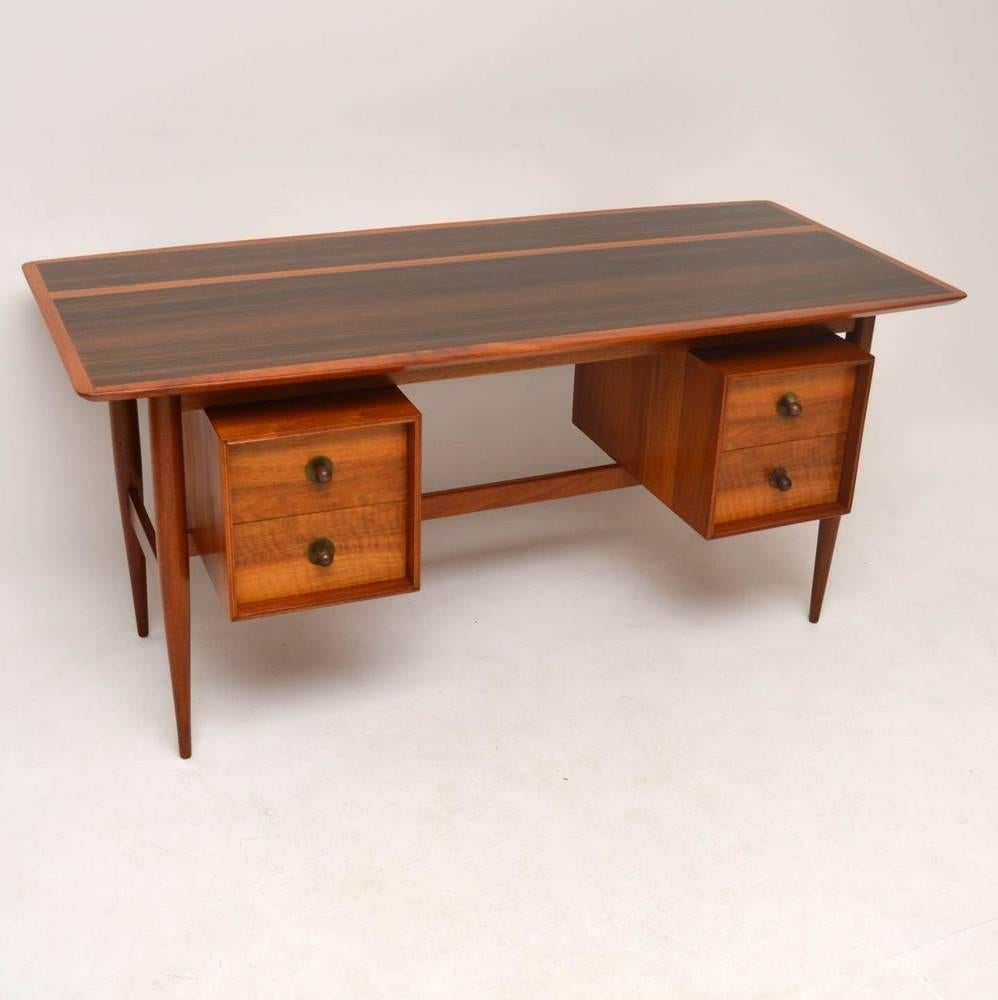 An absolutely stunning walnut desk from the 1950s, this is amazing quality and beautifully styled. The back has a gorgeous finish as well, so can be used as a freestanding item. We have had this stripped and re-polished to a very high standard, the