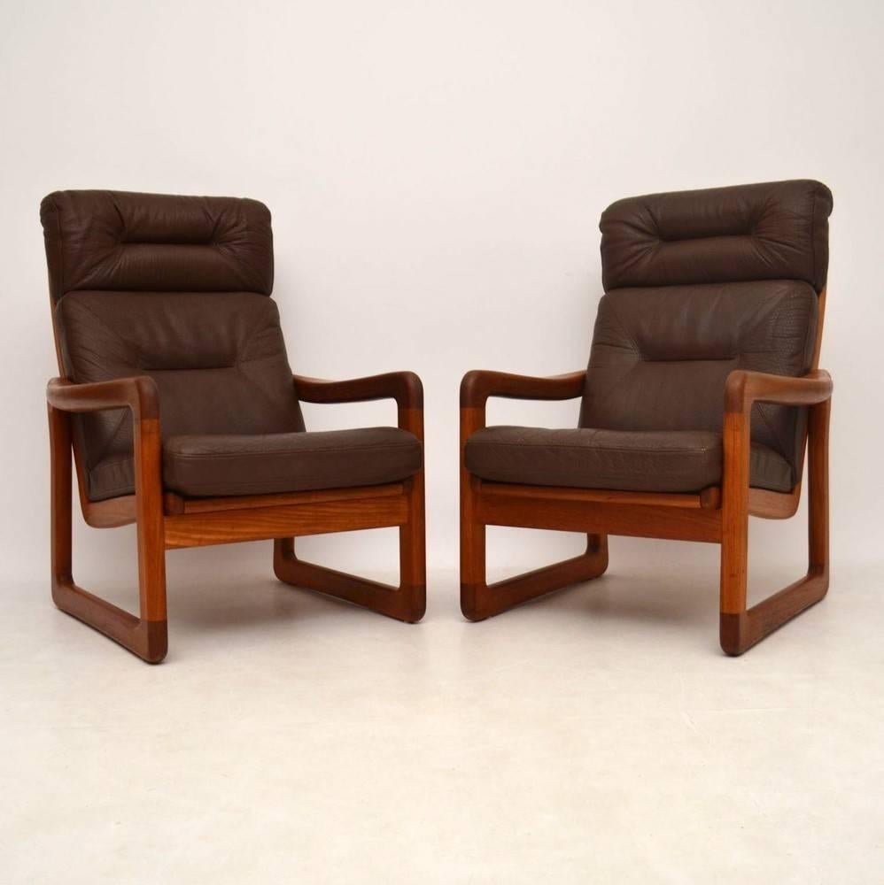 A very stylish and extremely comfortable pair of solid teak armchairs with brown leather cushions. These were made in Denmark by EMC furniture, they date from circa 1970s. They are in excellent condition for their age, with only some minor wear here