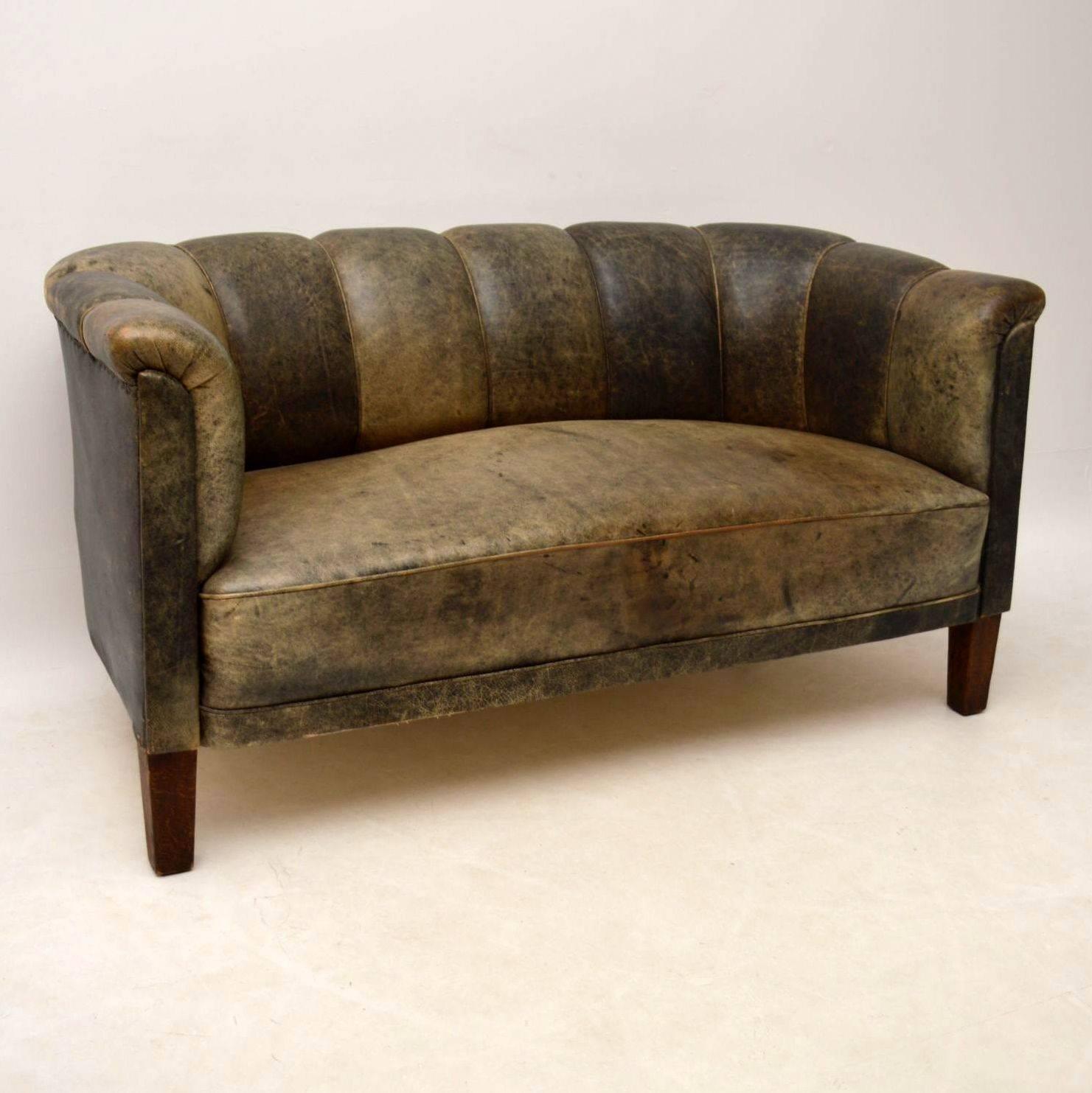This Swedish antique fluted back leather sofa has the most amazing original colored leather. It's naturally distressed and consequently the leather has many different shades of green and brown showing. Please enlarge all the images and have a look