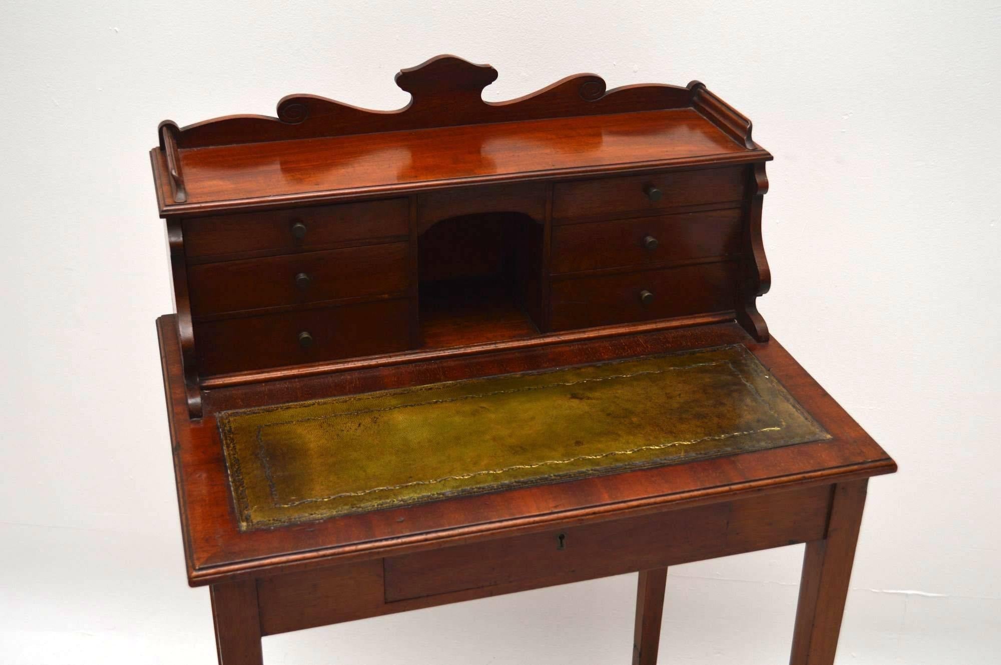 Small antique Victorian mahogany escritoire desk dating from the 1890s period. It has two banks of drawers either side of a pigeon hole above a tooled leather writing surface. There's a single drawer beneath that and there are four tapered legs.