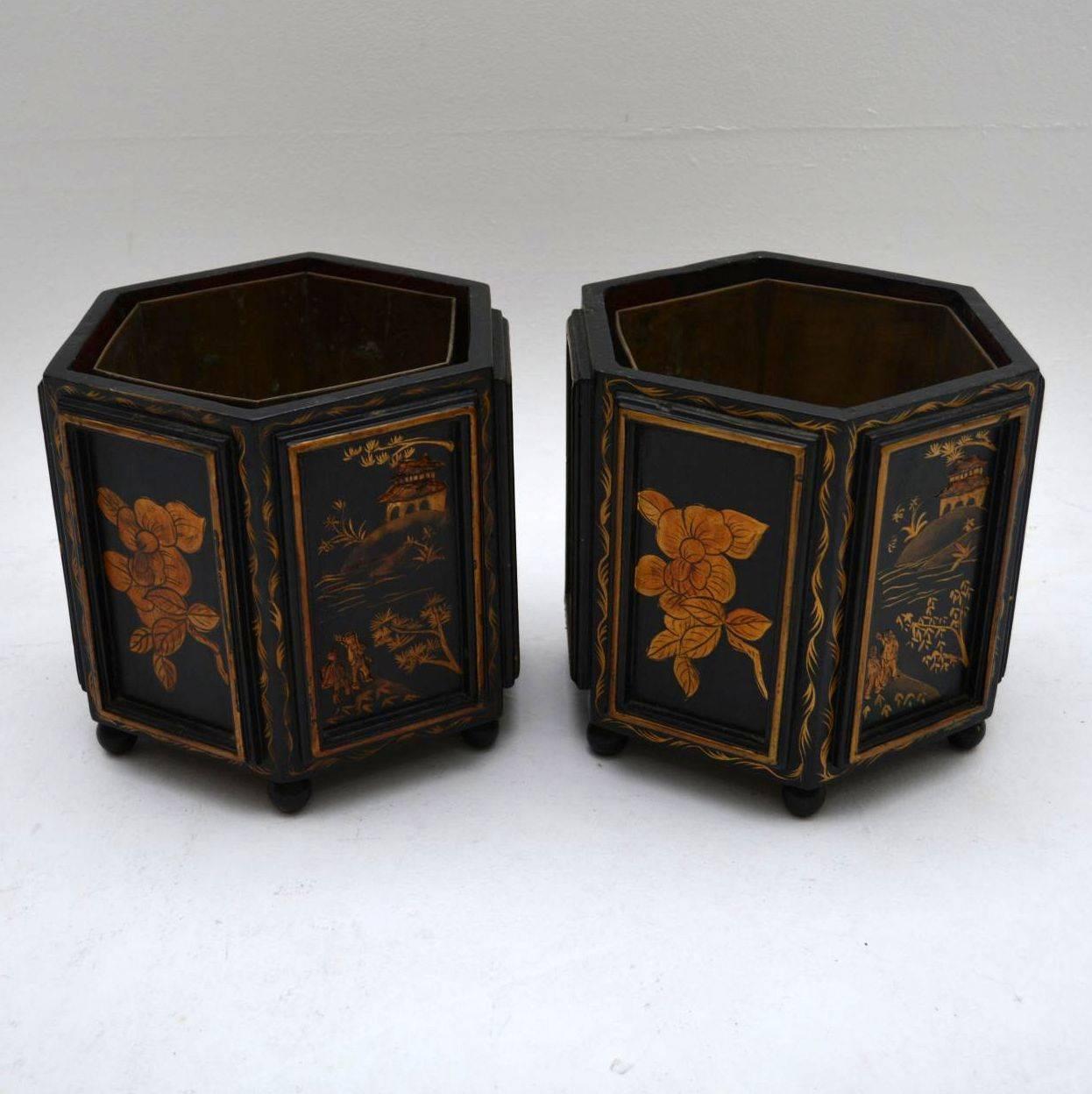 Pair of small antique chinoiserie plant holders in excellent original condition. They have the original copper liners inside which can be lifted out. These holders are beautifully decorated on black backgrounds and sit on small bun feet. Difficult