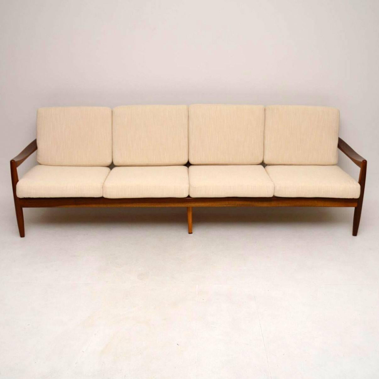 A stunning and unusually large Danish vintage sofa in walnut, this dates from the 1960s. We have had the frame stripped and re-polished, the cushions have been made from new and covered in our cream fabric; the condition is superb throughout. We