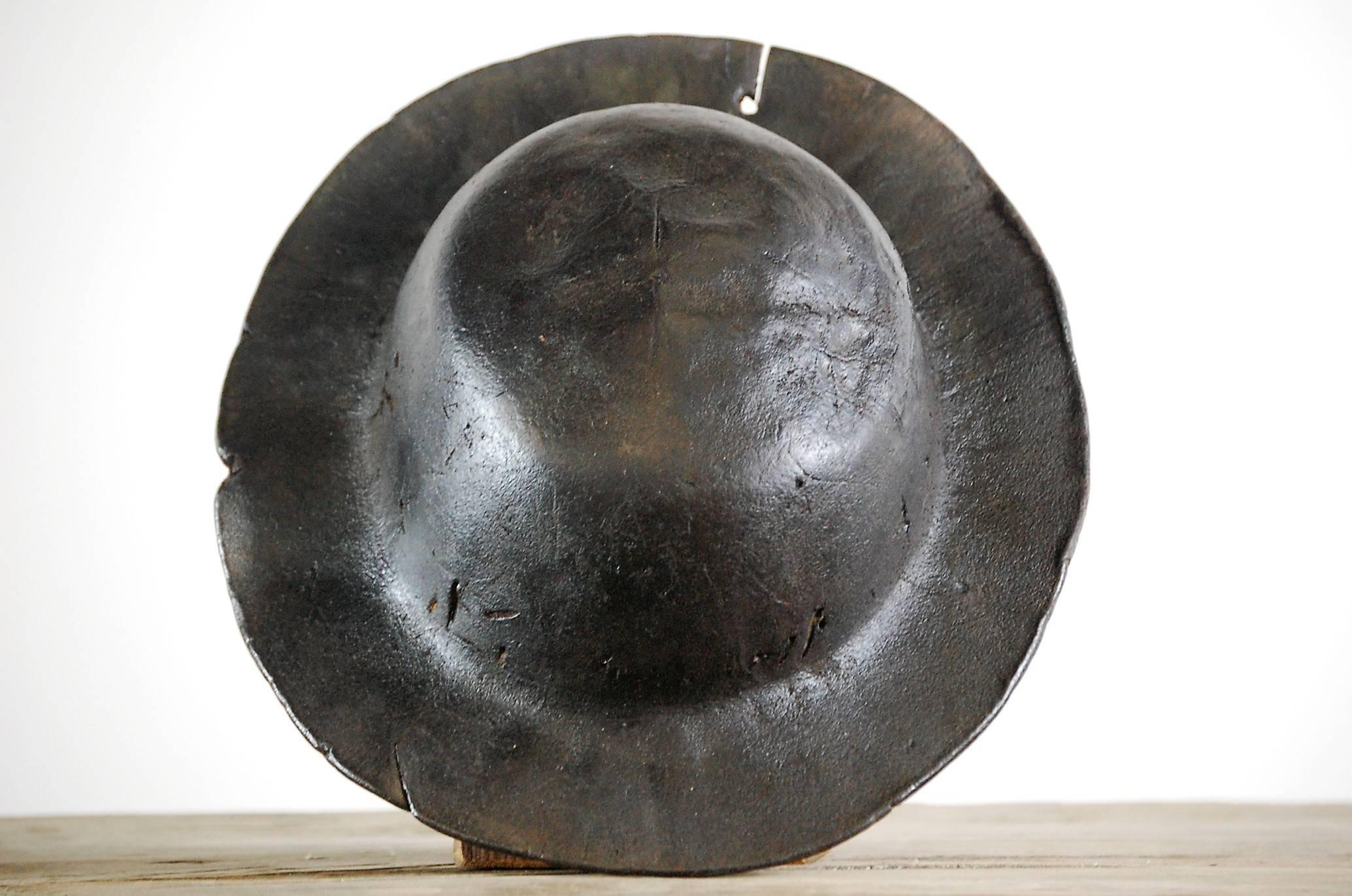 Casque de mineur ancien en cuir:: un exemple précoce de ce casque est fait de cuir. Le fait de tremper le casque dans l'eau avant de le porter permettait de l'ajuster au mieux et avait pour double objectif de rafraîchir le porteur lors des