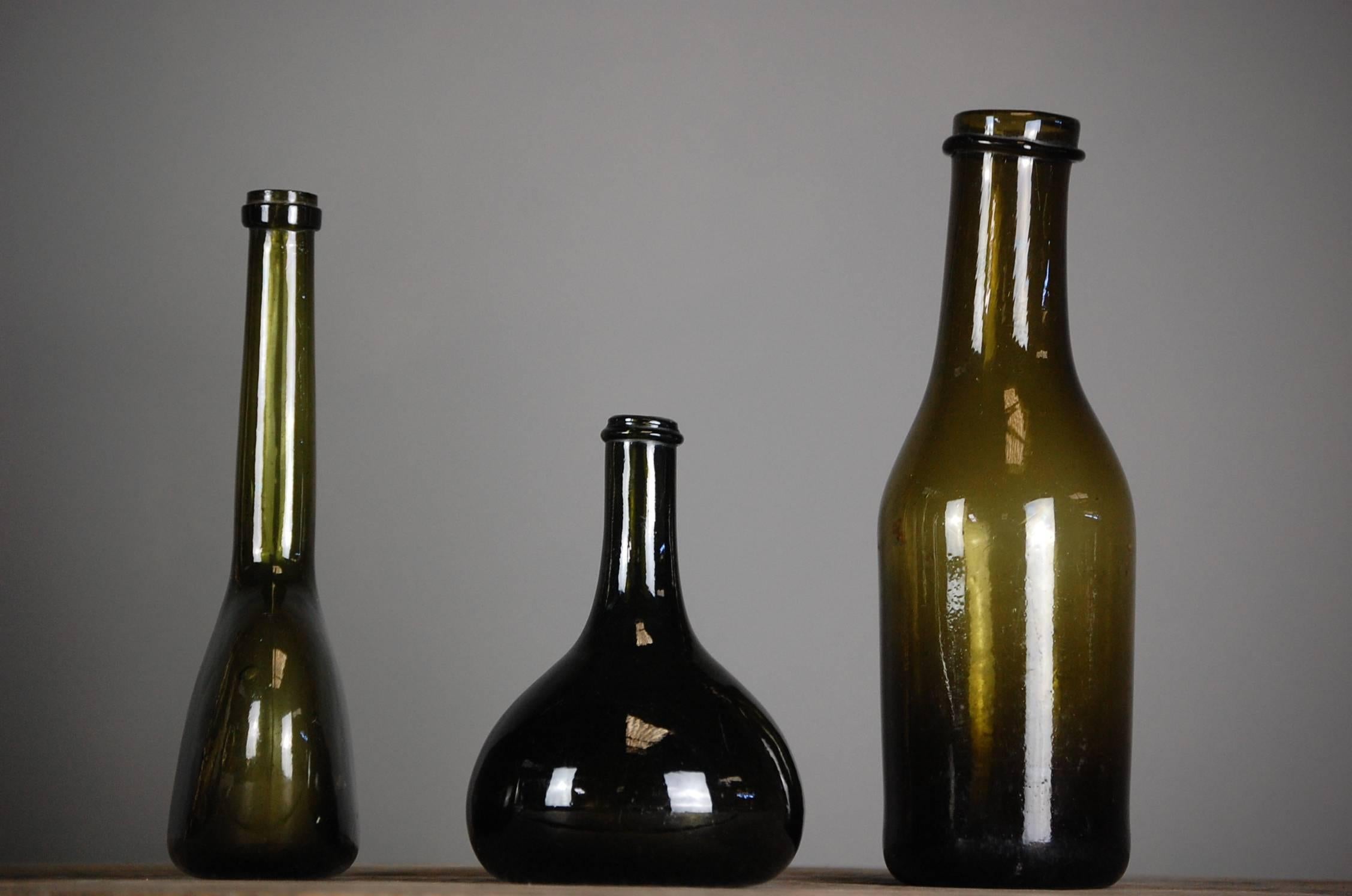 Collection of three early bottles, used for wine or spirit. All in perfect condition. The earliest being the middle bottle, circa 1680. Wonderful decorative collection. All handblown.