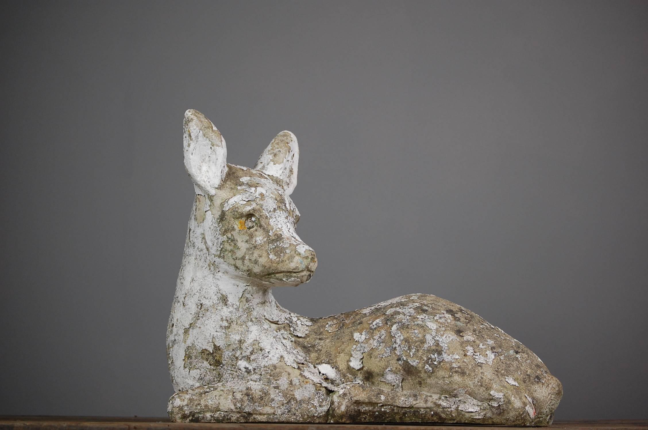 Weathered 20th century concrete deer statue. Well patinated with remnant flakey white paint.