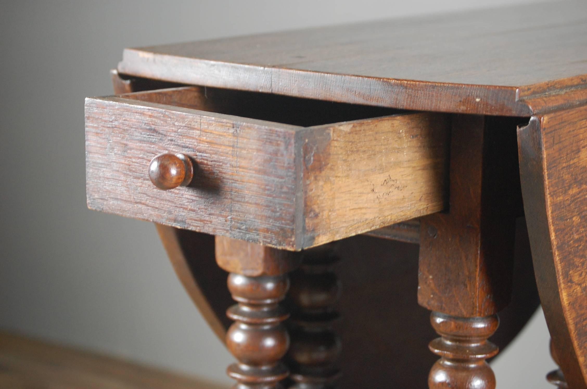 Early 19th century English oak oval gateleg table, simple apron to turned legs, pegged construction. simple stretchers with carved detail, raised on turned feet. Nice patination and wear.