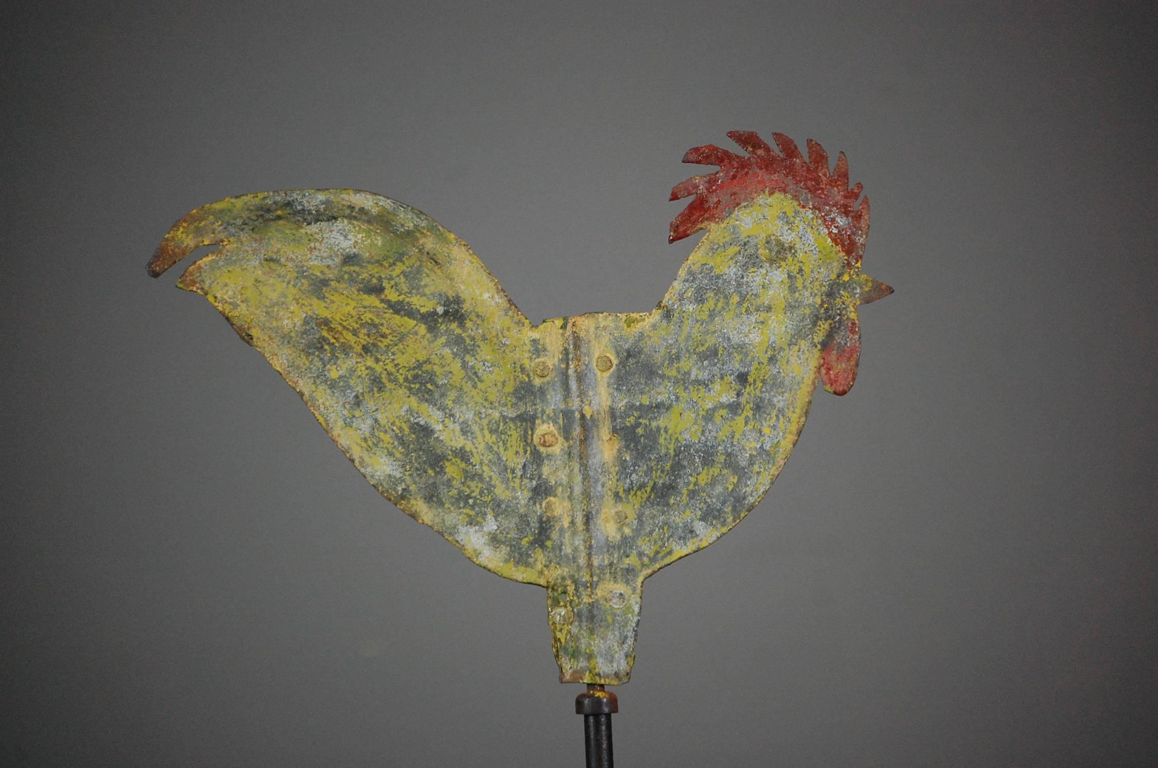 Early 20th century diminutive silhouette cockerel weathervane, retaining traces of original paint. Naive in construction. Working repairs. More than likely to have originated from a chicken coop. Contemporary bespoke stand. Still spins, France,