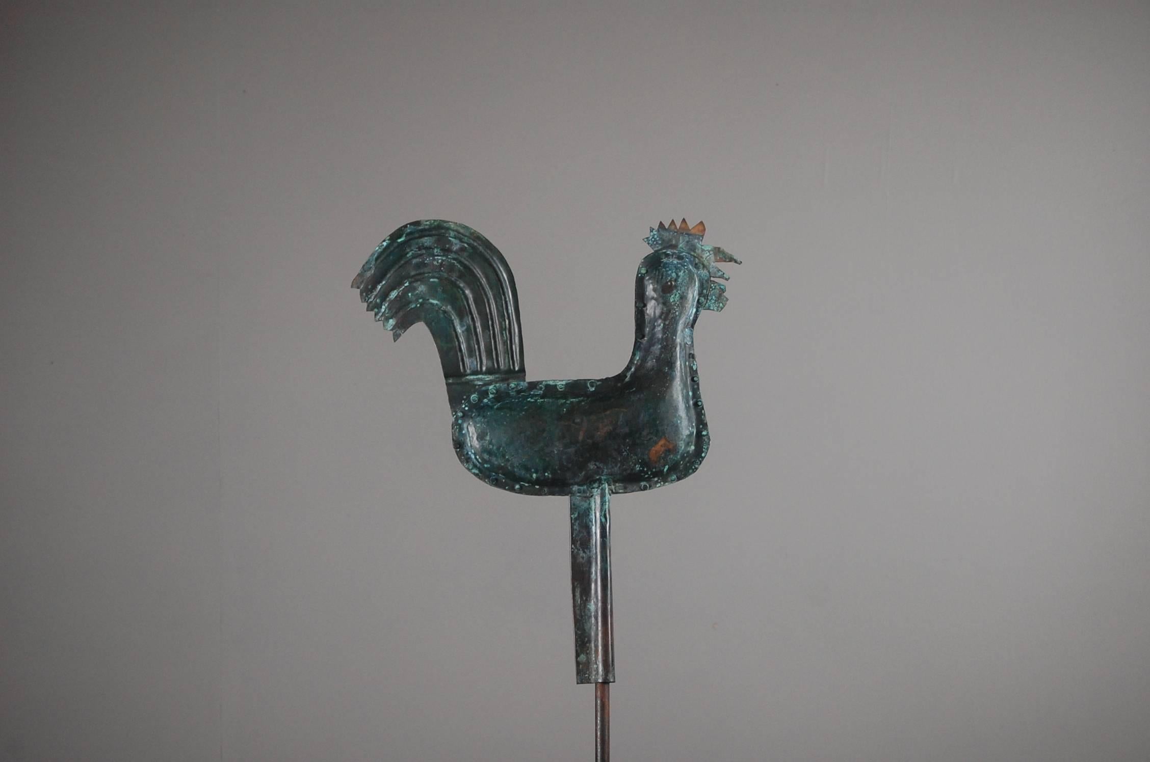 Naïve Cockerel weathervane or Coq de Clocher, naïve construction, full bodied with stylised tail, heavily oxidised, with light verdigrises’ in places. Contemporary steel stand. France, early 20th century. Measurements inclusive of stand.