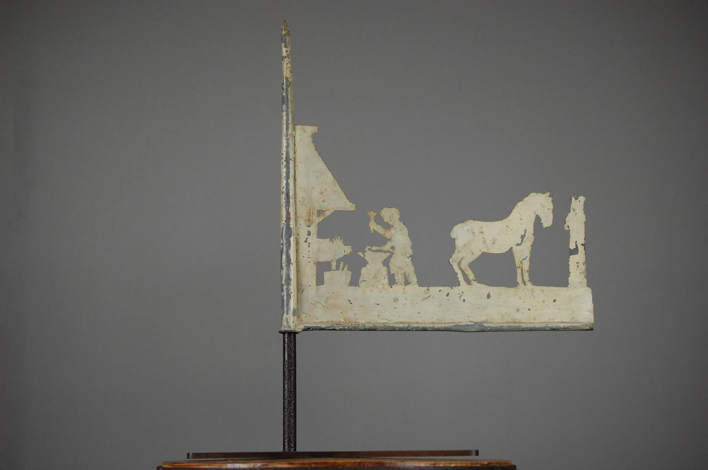 Early 20th century Silhouette weathervane, painted sheet zinc. Depicting a blacksmiths workshop. Later aged stand, measurement includes stand, France, circa 1930.