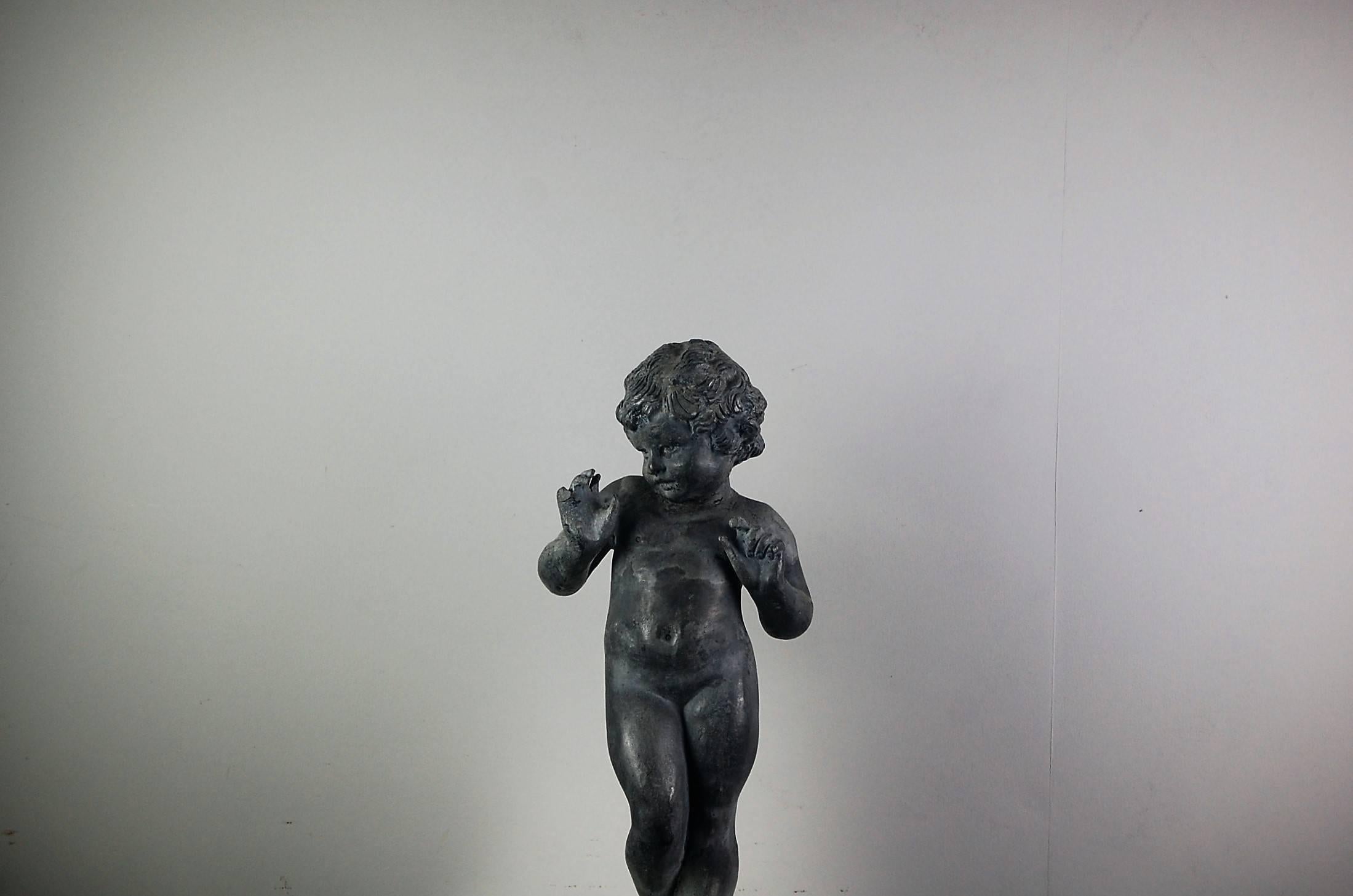 Delightful depiction of a dancing putti or cherub in lead, historical restorations, English, early 20th century.