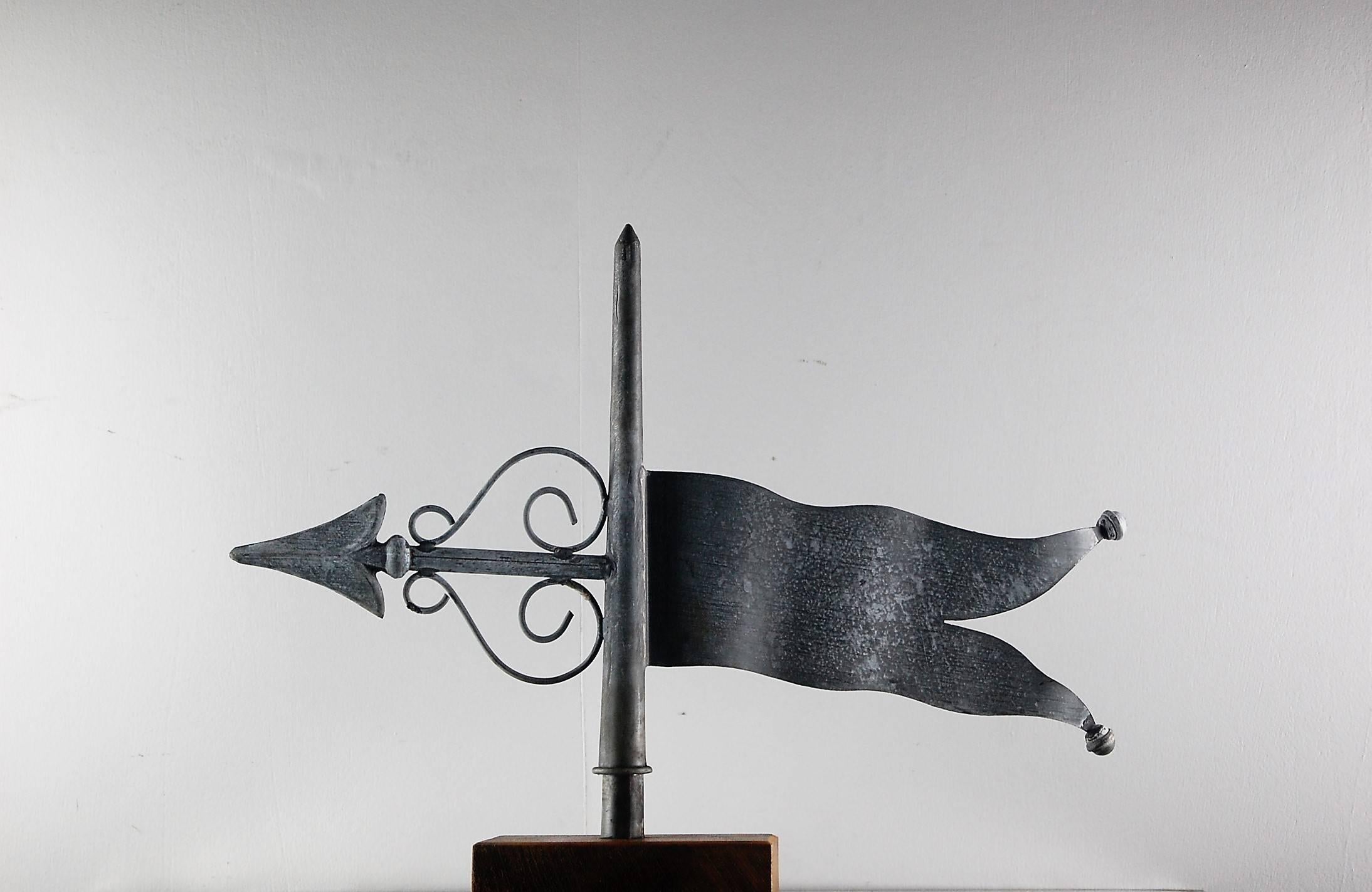 Early 20th century flag banner weathervane of zinc. Fabulous movement in the flag itself. all original although appears to have had minor working repairs throughout its lifetime. Mounted on a contemporary timber stand, still spins, France, 1950.