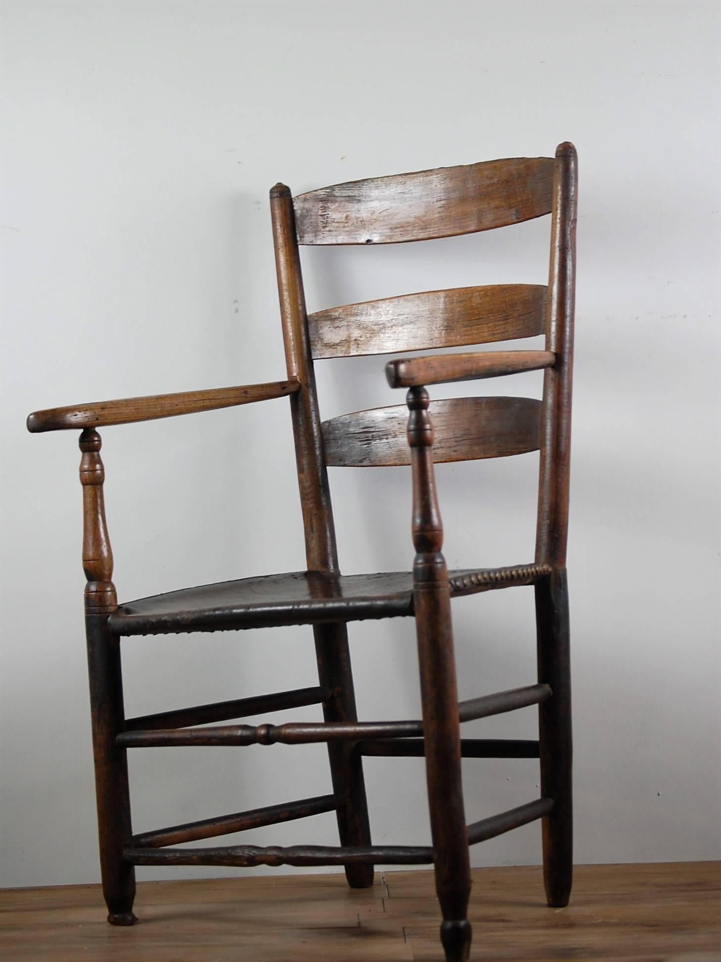 Wonderfully worn 19th century Provincial French cherrywood carver, Used by a wood carver, presumably a right handed carver who has slowly worn away the base of the front right leg of the chair. Leaving it totally solid but wonderfully wonky. Thick