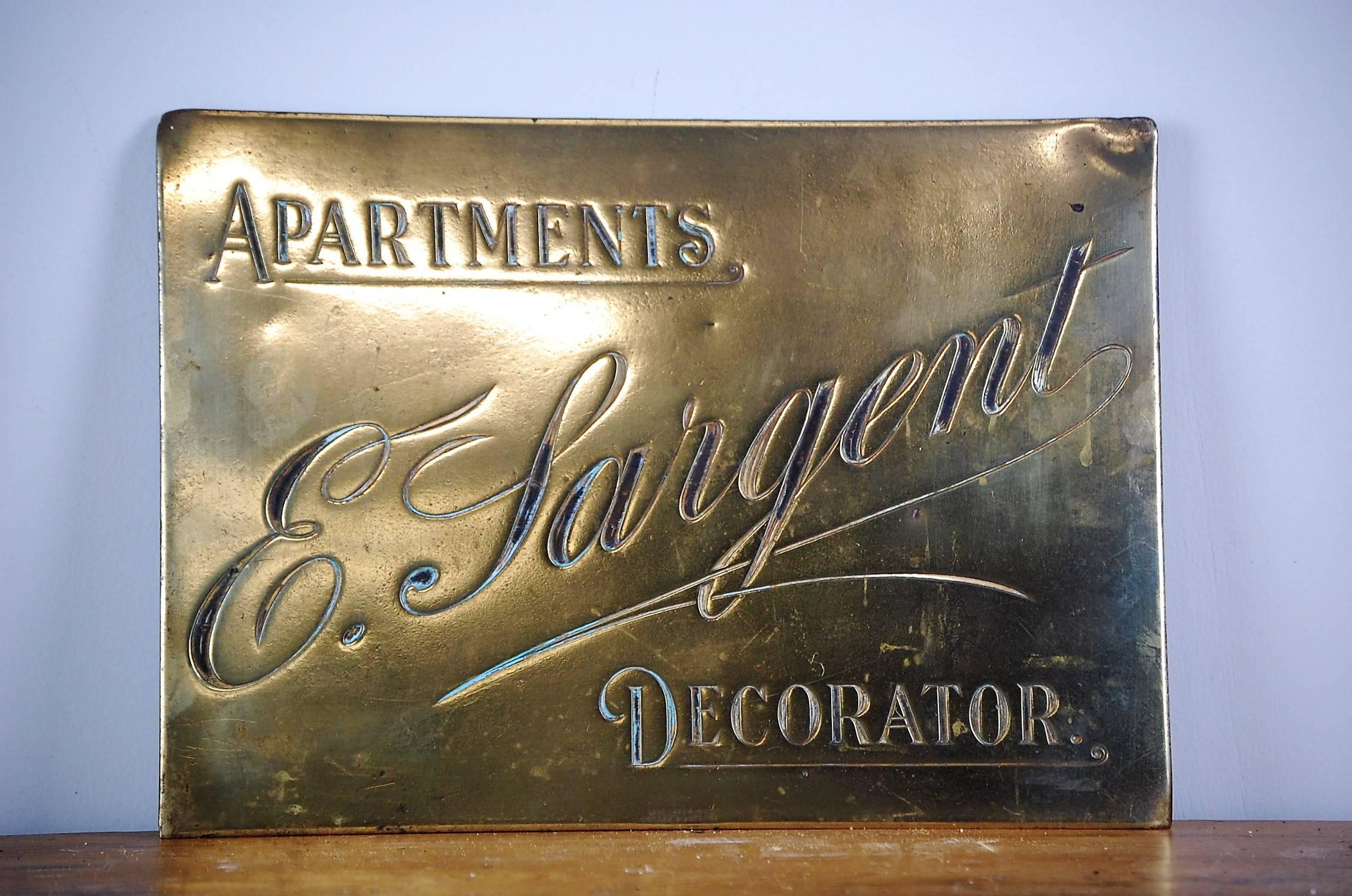 Delightful early 20th century English brass plaque decorators trade sign, bearing the inscription E. Sargent, apartments decorator. Research does not indicate anything of note however the makers mark would suggest this was probably used in either
