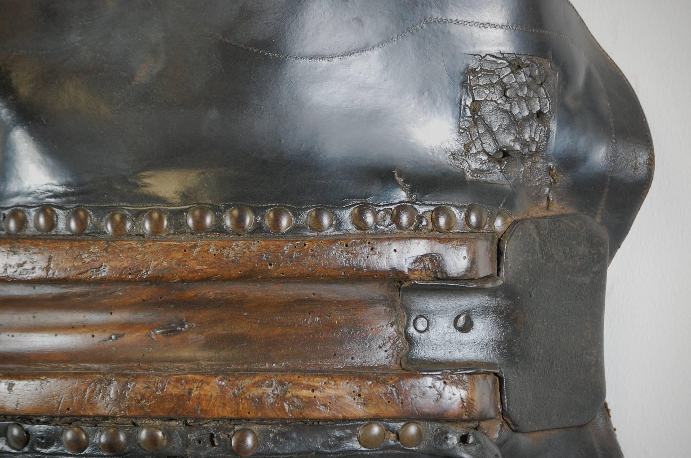 Early pit pony saddle, Welsh in origin. Wonderful combination of wood, leather and iron. Each taking on its own unique patination from years of service. The channel is made from wood and is heavily worn. Stud work fixes the leather to the wood with