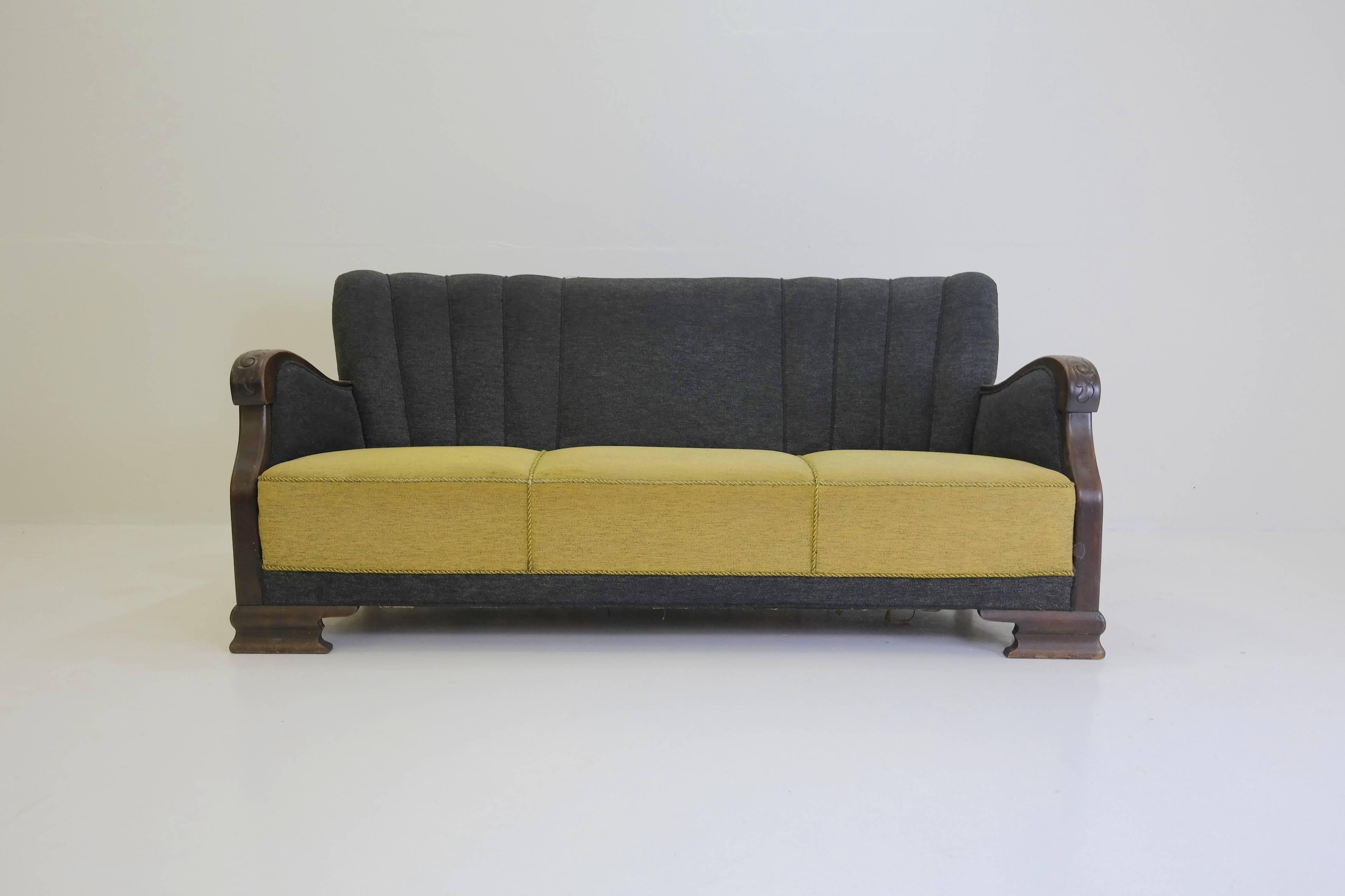 Super stylish 1930s Danish sofa. Still in its original two-tone fabric and with all its old-world charm. The feet and armrest are carved walnut, with a sturdy beechwood frame. This is a very hard to find Danish original, and it would make quite a