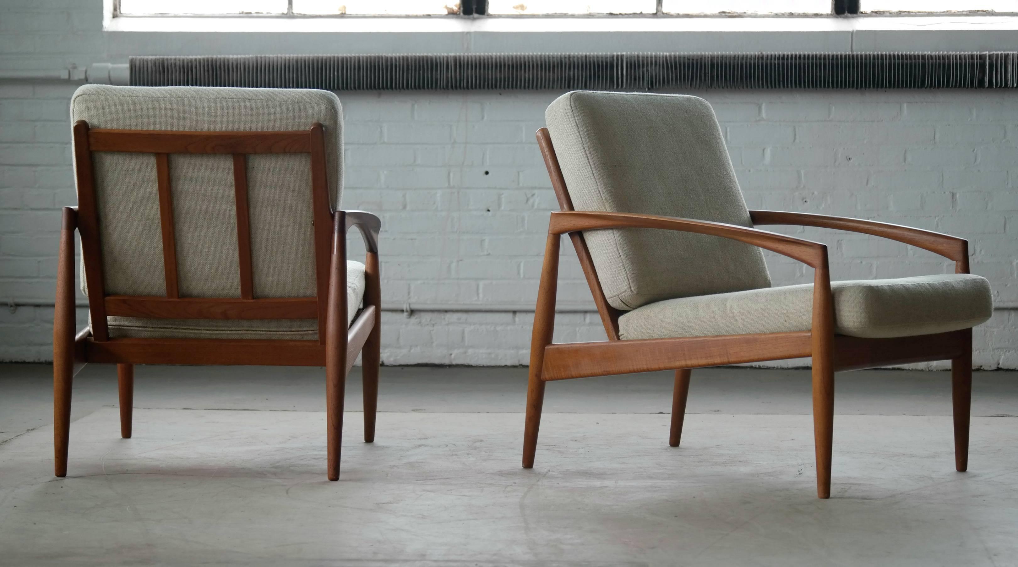 Beautiful pair of model 121 known as the paper knife teak easy chairs by Kai Kristiansen manufactured by Magnus Olesen, Denmark. Made of solid teak wood and is of superb quality. Great clean lines and amazing details. The chairs still have their
