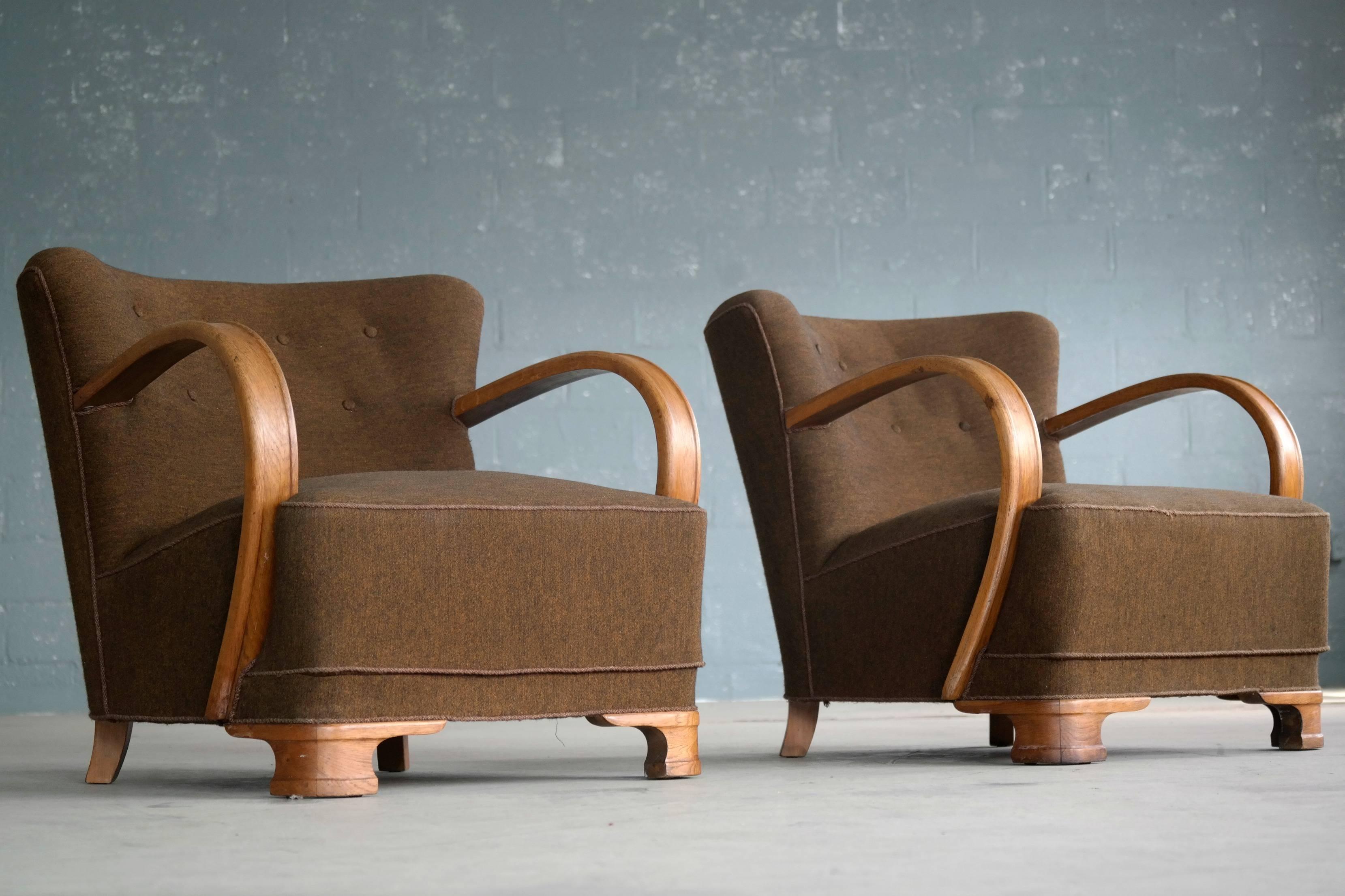 Superb pair of Danish Art Deco chairs from the early 1940s with spring cushions and solid oak armrests and feet in the style of Viggo Boesen and Flemming Lassen. Very expressive low slung proportions. Art Deco works very well in combination with any