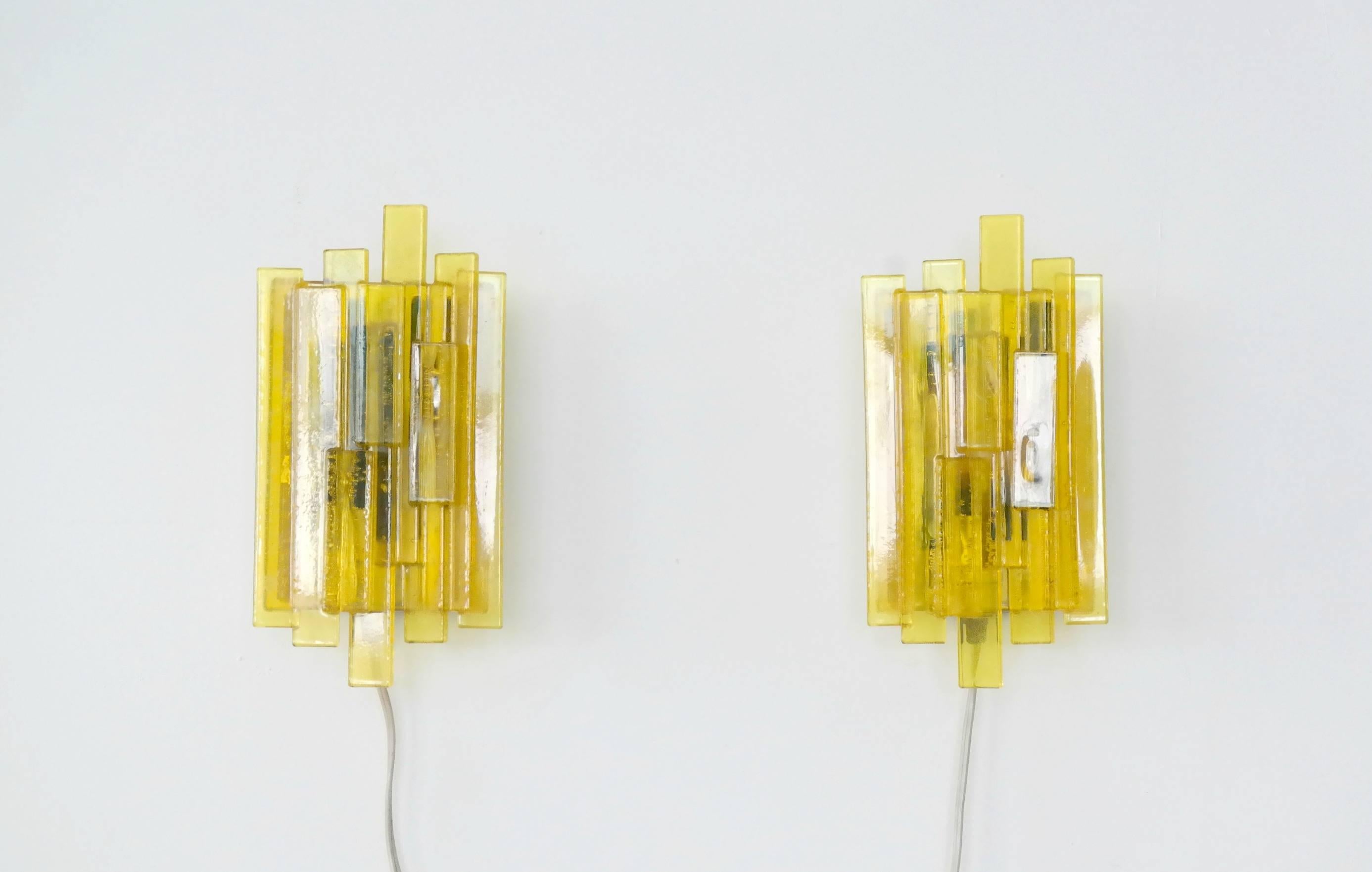 Very attractive pair of Space Age geometric wall sconces by Danish designer Claus Bolby. Made circa 1970 from yellow acrylic resin of different shapes and sizes on top of green acrylic in the centre. Excellent condition.
 