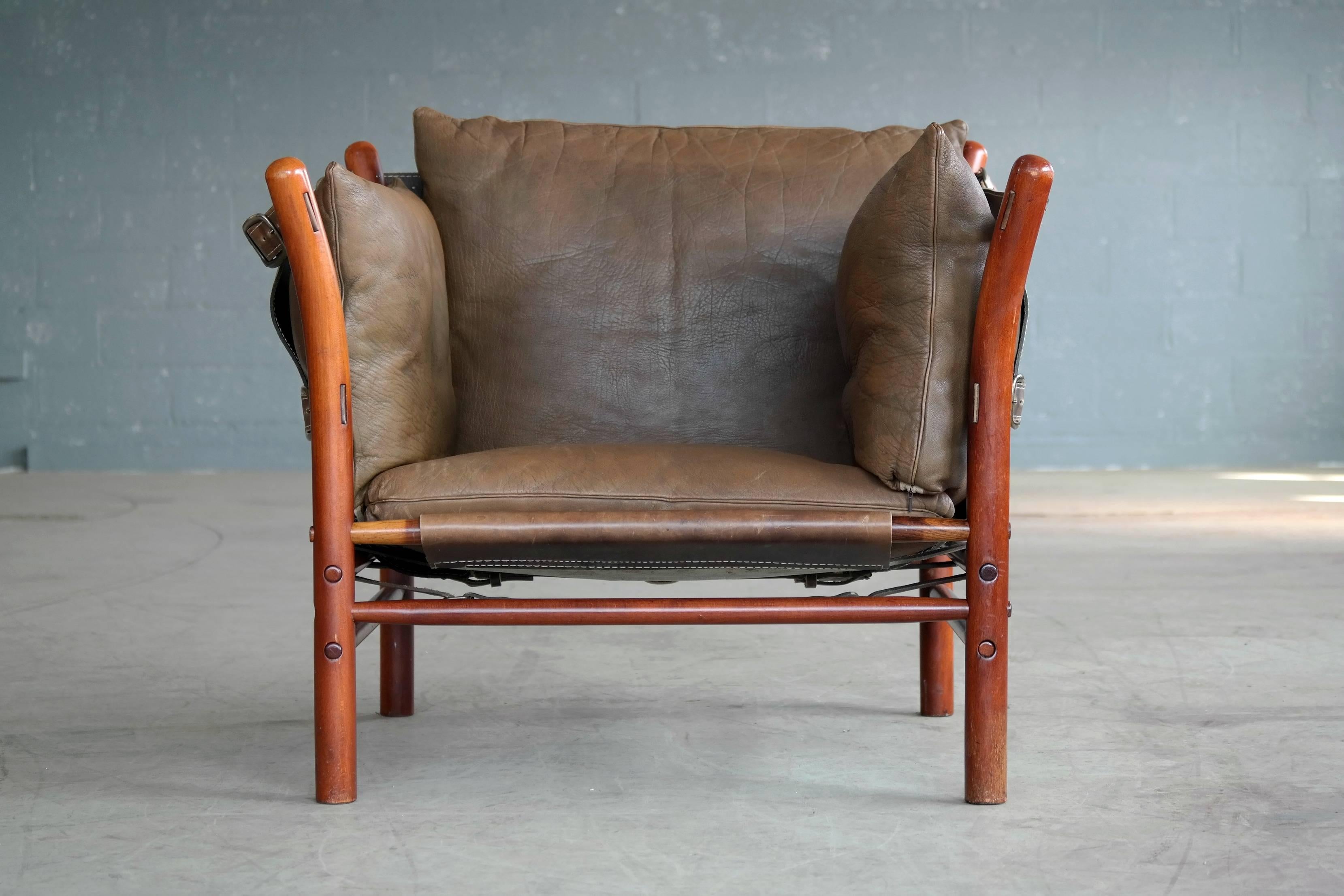 Beautiful 1960s safari chair and ottoman in chocolate brown colored buffalo leather and stained beechwood designed by Arne Norell in the 1960s for Norell Mobler, Sweden. The chair is assembled without any screws or hardware and held together by the