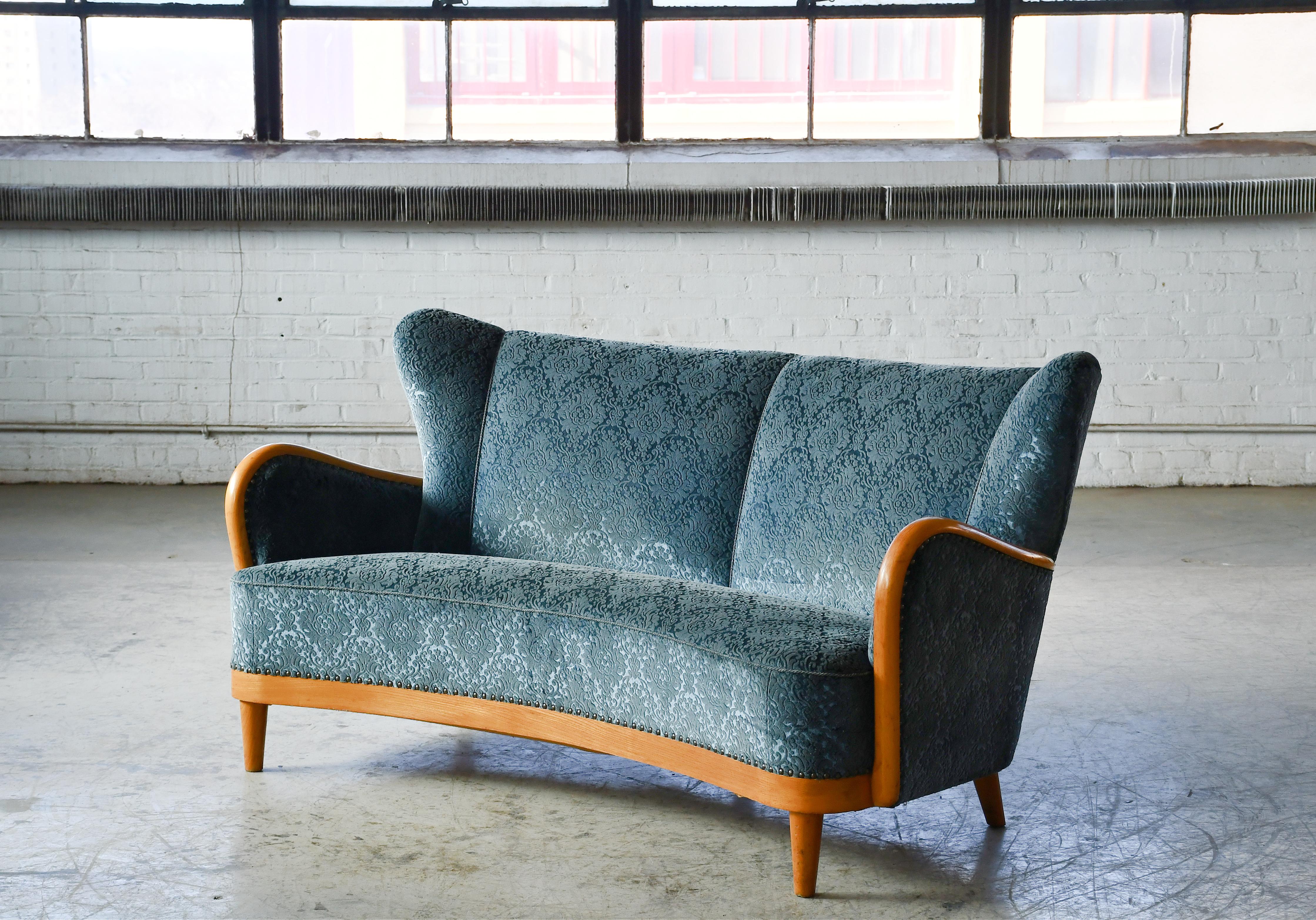 Stunning classic Danish curved sofa from the 1940's. In the  the style of Fritz Hansen and Alfred Christensen with  armrests in beautifully carved maple Nice slim elegant silhouette. Solid and sturdy construction with spring coils in the seat and