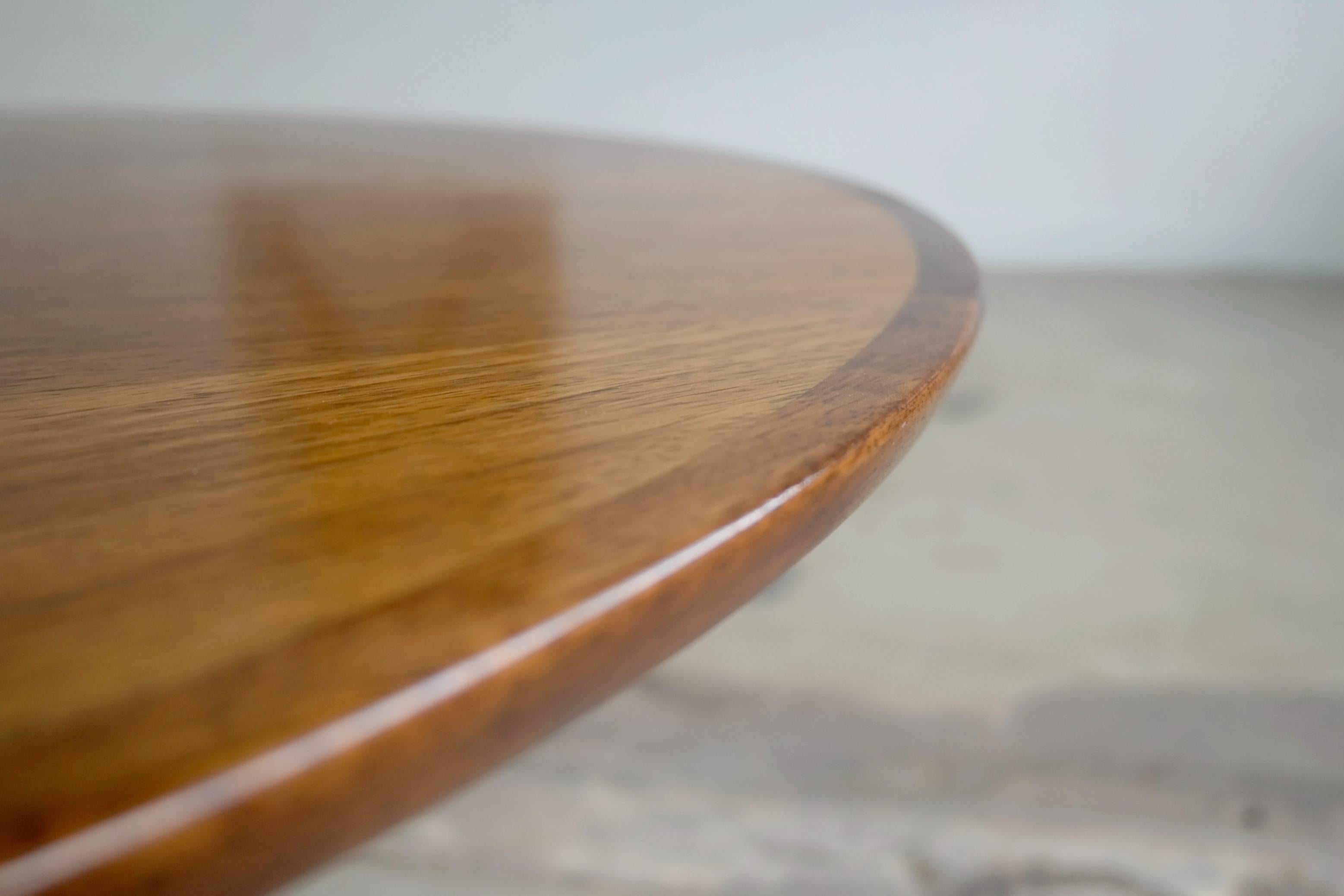 Round coffee table with a rosewood top and a brushed aluminum base designed by HW Klein for Bramin Mobler Denmark in the 1960s. The table is in excellent condition with some sun fading to the rosewood giving it a nice honey-golden color coveted by