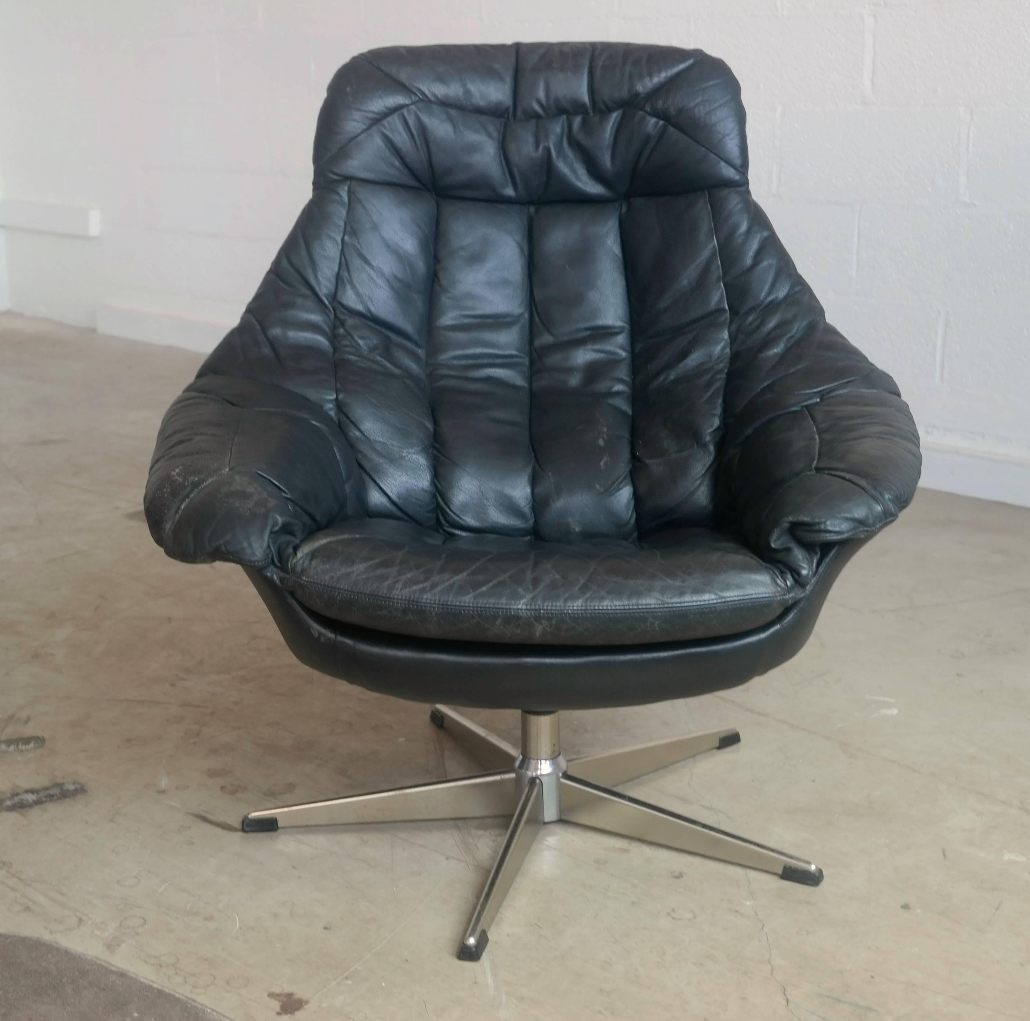 Fantastic pair of highback swivel lounge chairs with one ottoman designed by H.W. Klein for Bramin, Denmark, circa 1970. Upholstered in original rich black tufted leather and mounted on five-star metal swivel base, these chairs are magnificently