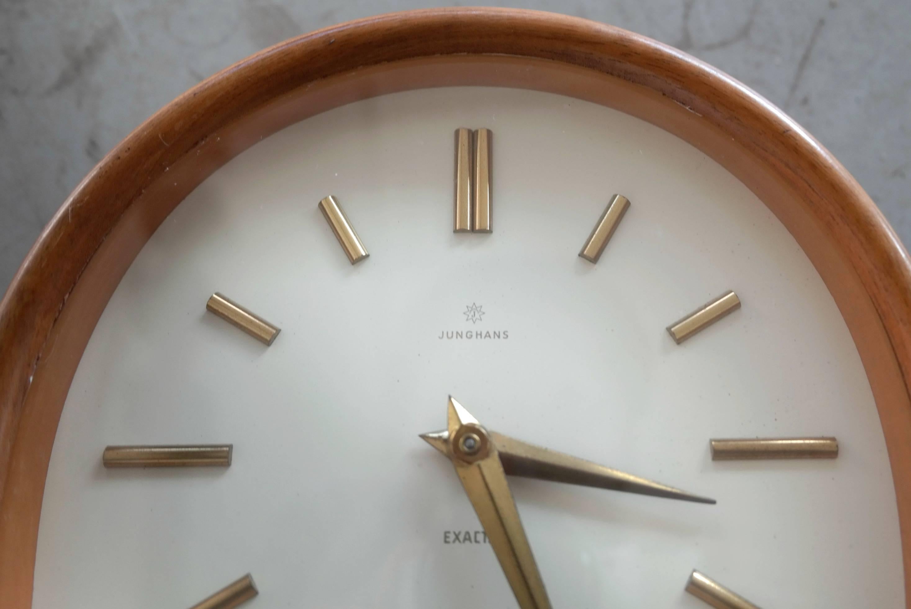 This table clock is a wind up variety and makes a truly serene chime on the hour. It has a teak wood surround. The hands are polished brass and some slight pitting can be seen up close. Made in Germany and still works great!