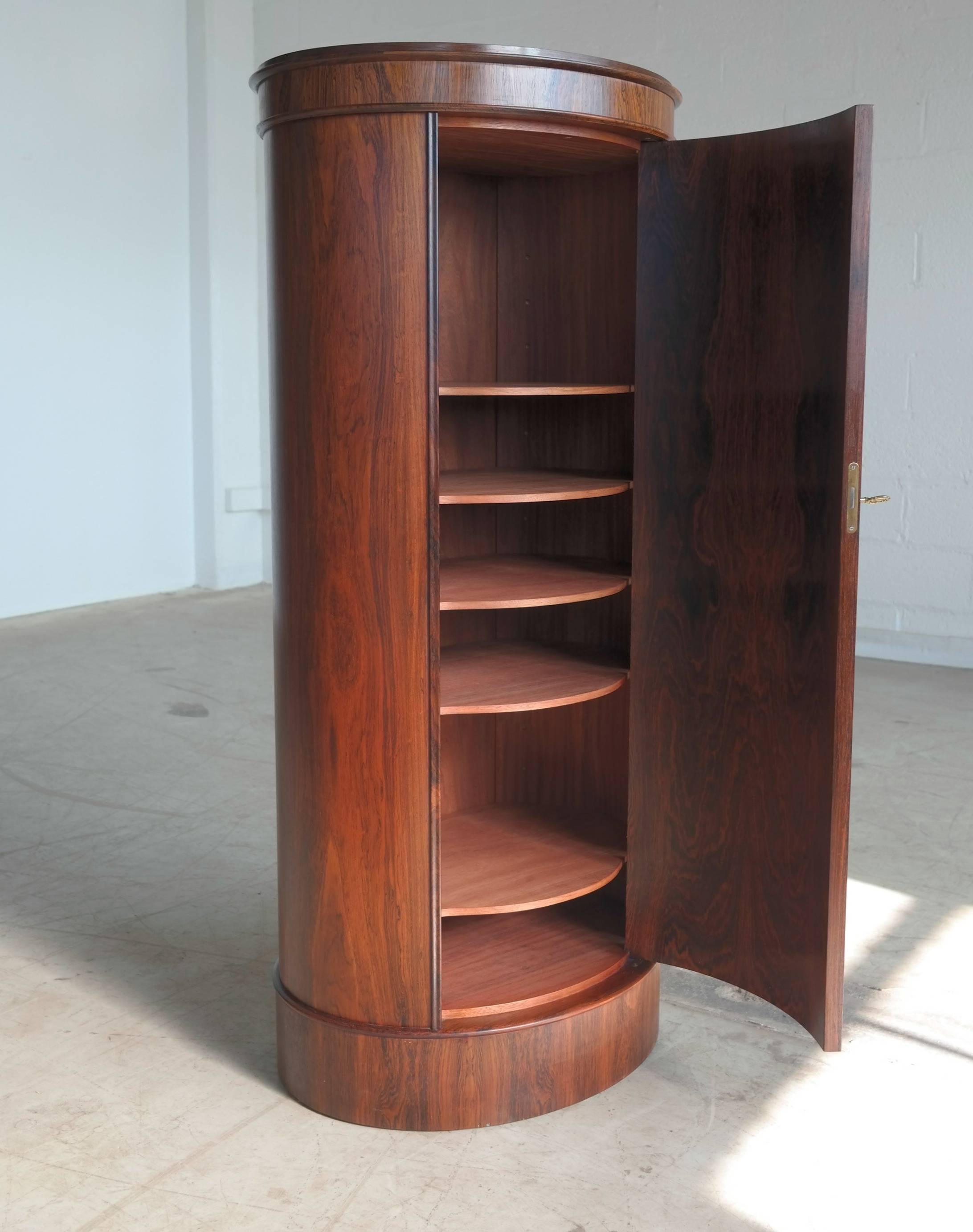 Exquisite oval shaped pedestal cabinet or bar designed by Johannes Sorth for Bornholms Møbelfabrik, Nexoe, Denmark. Highest quality craftsmanship and beautiful color and grain figure from a now defunct manufacturer on the Island of Bornholm in the