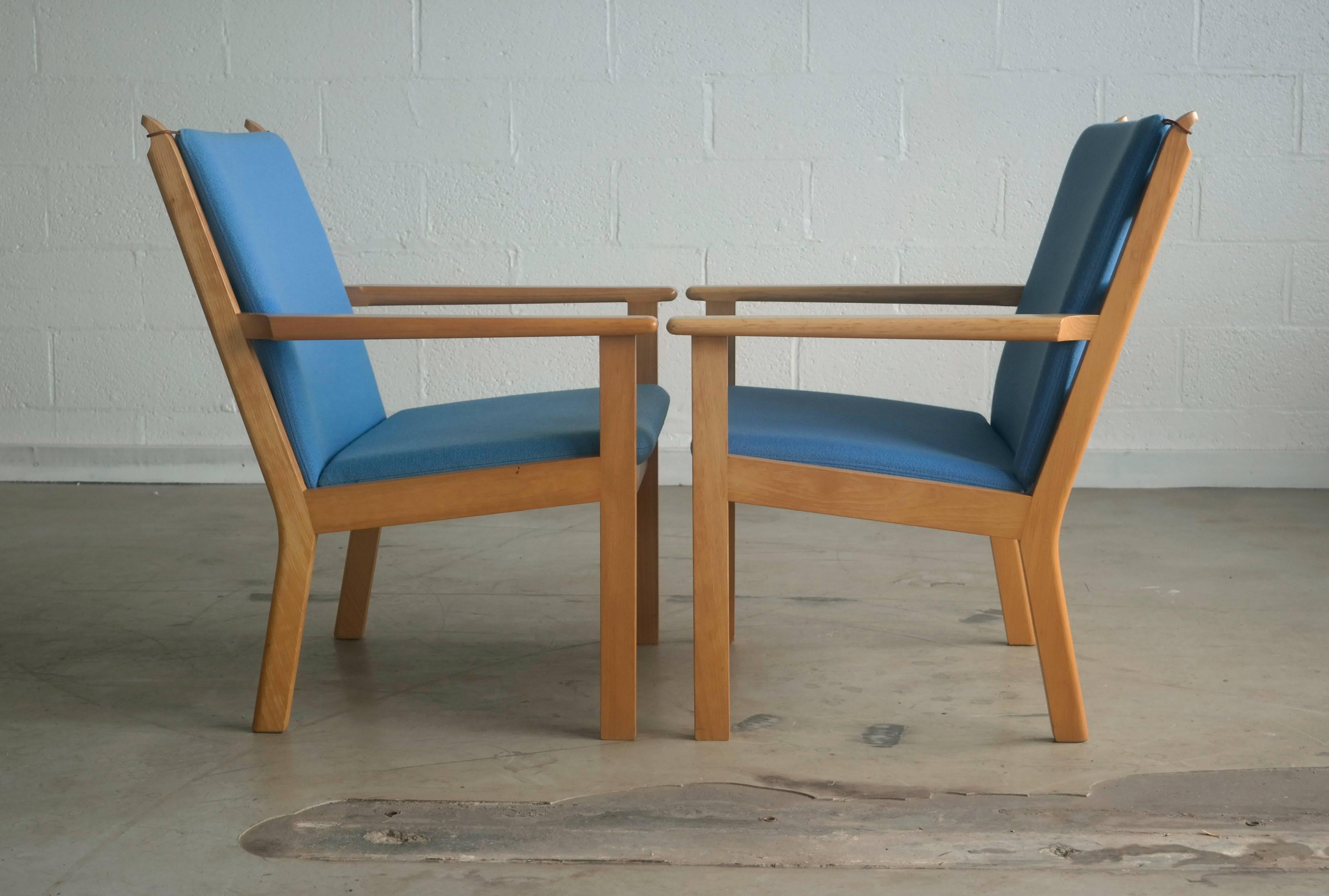 Two elegant Danish easy chairs Model GE 284 designed by Hans Wegner for GETAMA, Denmark. Chairs are made of solid beech wood and original wool fabric by Kvadrat. Some slight scuffing and scratches based on normal wear but overall in great condition.