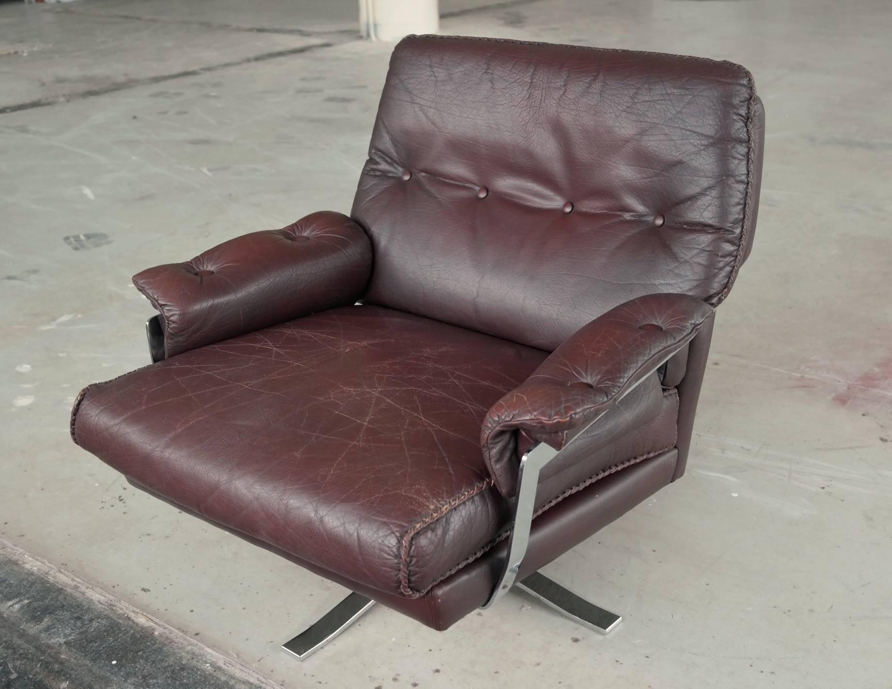 Beautiful hand-stitched chair in chocolate brown top grain buffalo leather designed by Arne Norell for Vatne Møbler. The leather is supple with great patina. A couple of small scuffs on the back of the chair. Stainless steel base and frame in