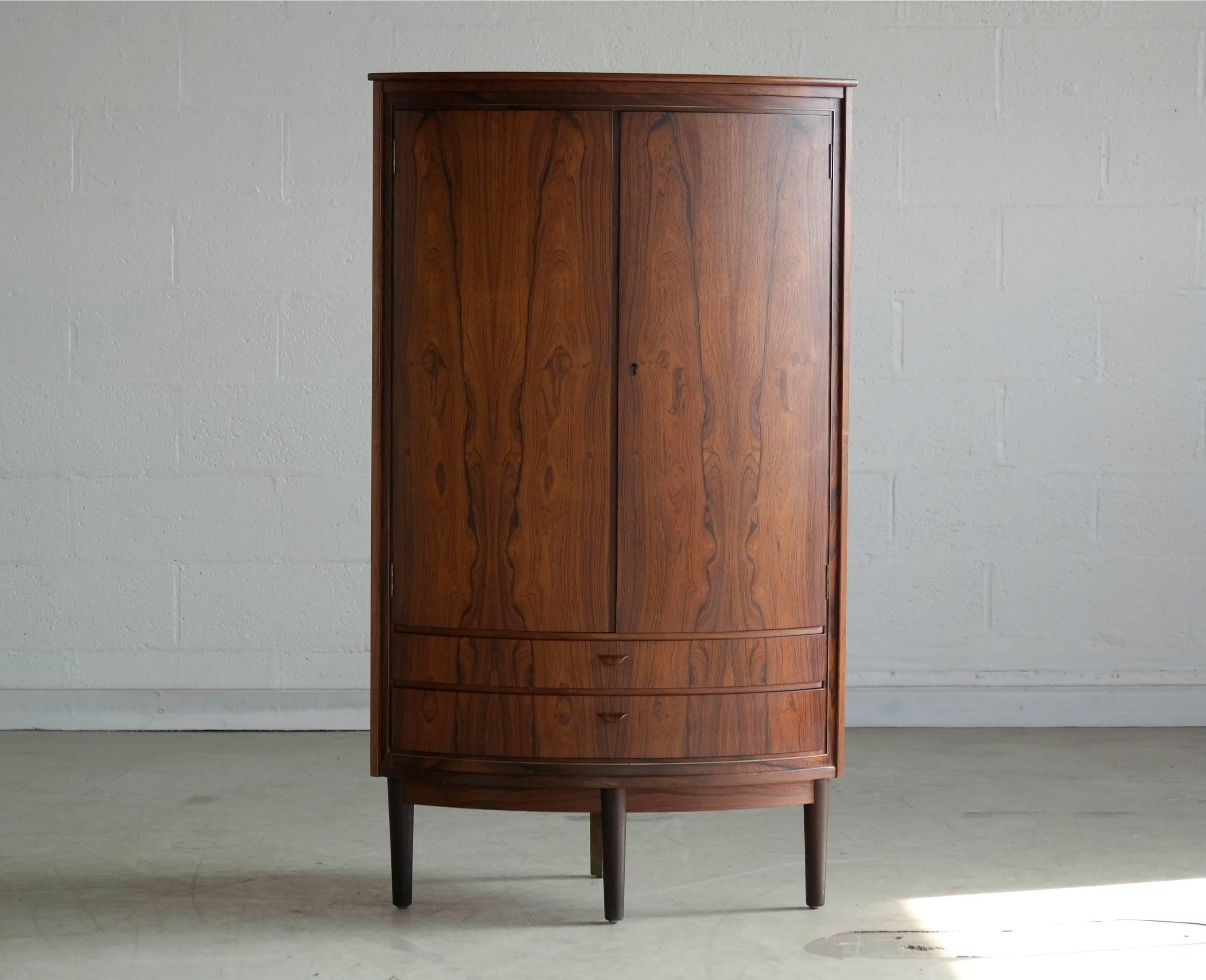 Superb Rosewood corner cabinet of superior quality and craftsmanship. Beautiful rosewood grain figure and color with solid edges and carved pulls. Excellent condition. Corner cabinets don't get better than this.