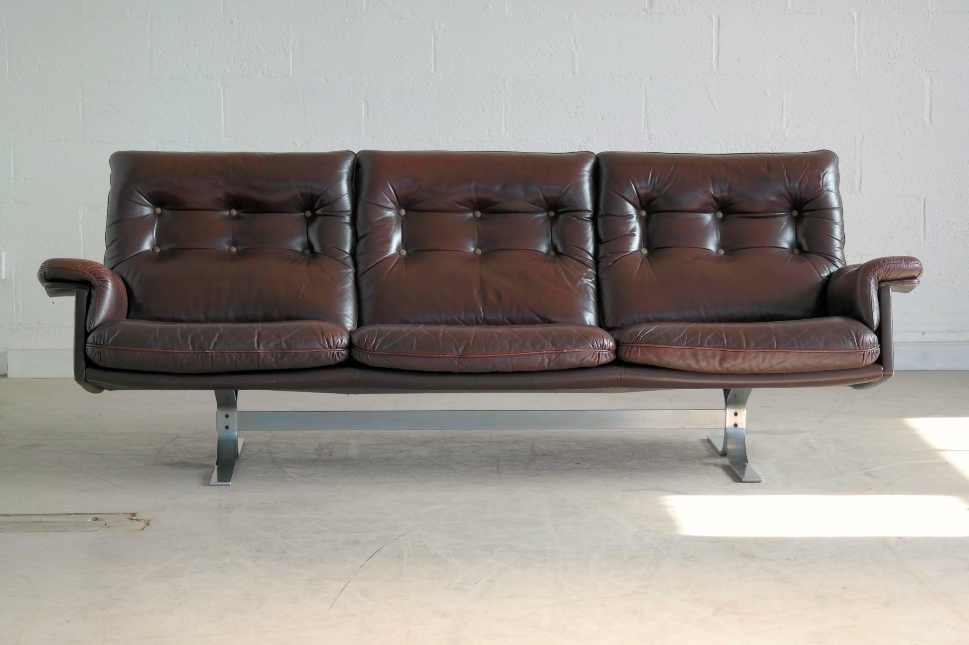 Beautiful and ultra-cool sofa in brown patent leather by Arne Norell and manufactured by Vatne Møbler, Norway. While the style is typical for Norell this model is quite rare. The condition is very good with no rips or tears to the leather although