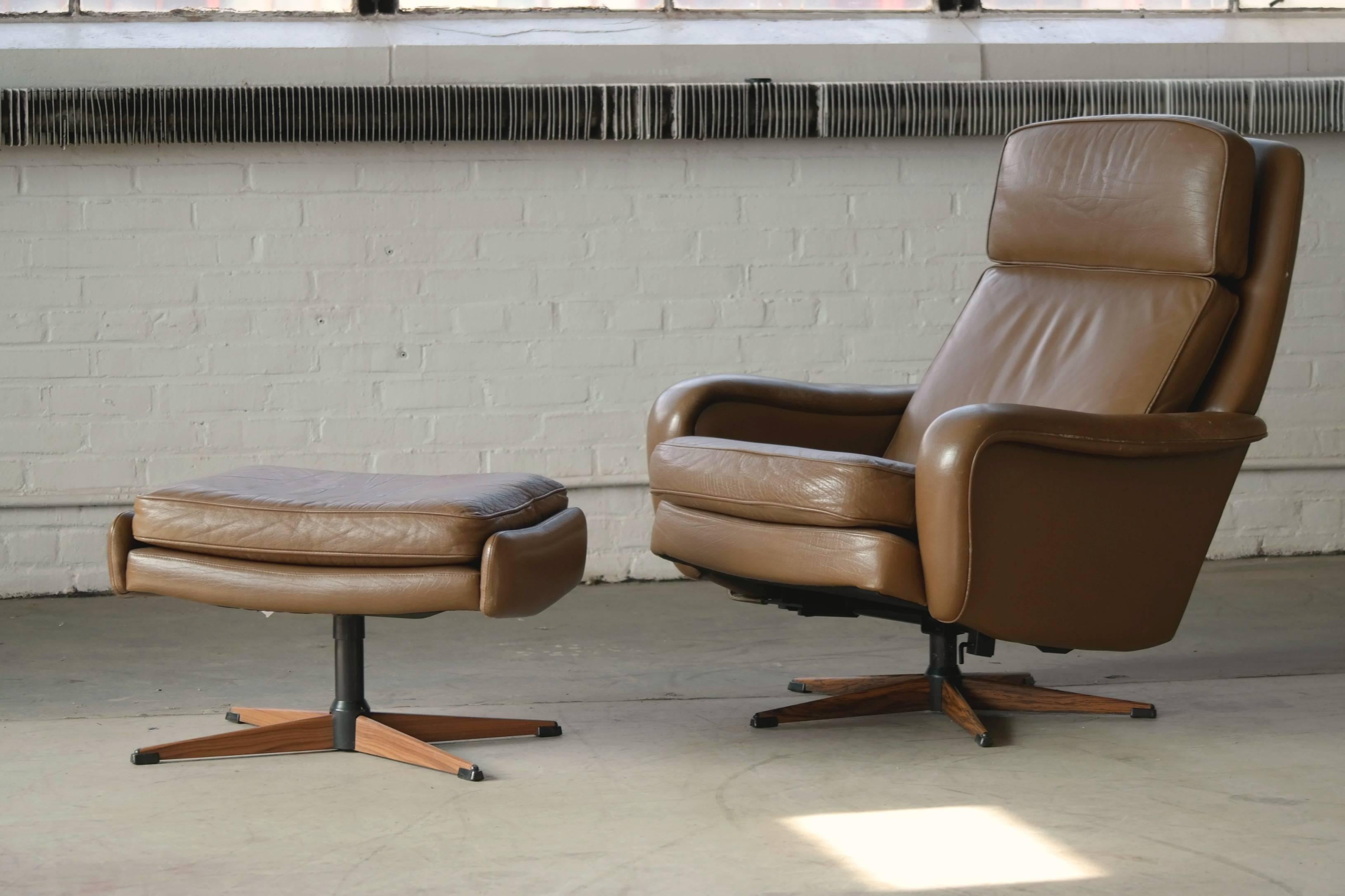 Superb Danish Mid-Century leather swivel lounge chair with ottoman by
Madsen & Schubel. The same high quality that so typical for this maker. The bases are made of steel with imitation wood accents.