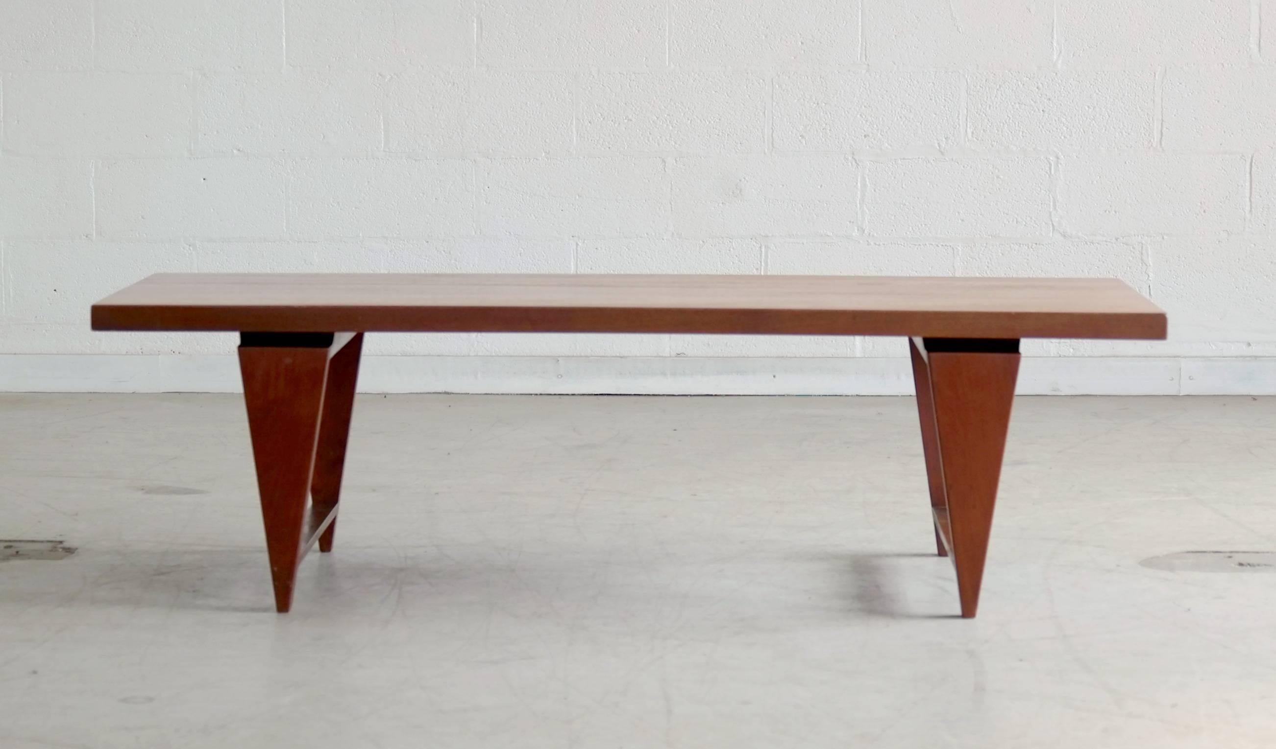 Coffee table by Illum Wikkelsø with distinctive triangular legs and floating top. In solid teak, this table has a strong, graceful presence with its rather solid upper resting almost tip-toeing on its four points.
